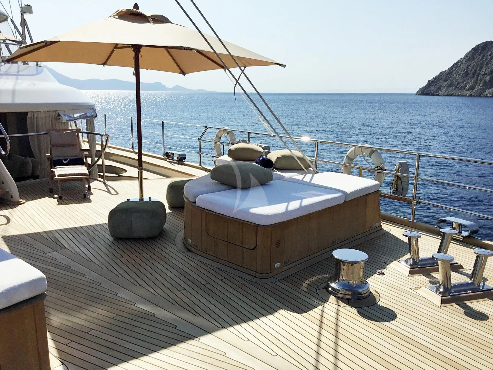 a deck with a large bed and umbrellas on it aboard LA LUNA Yacht for Sale