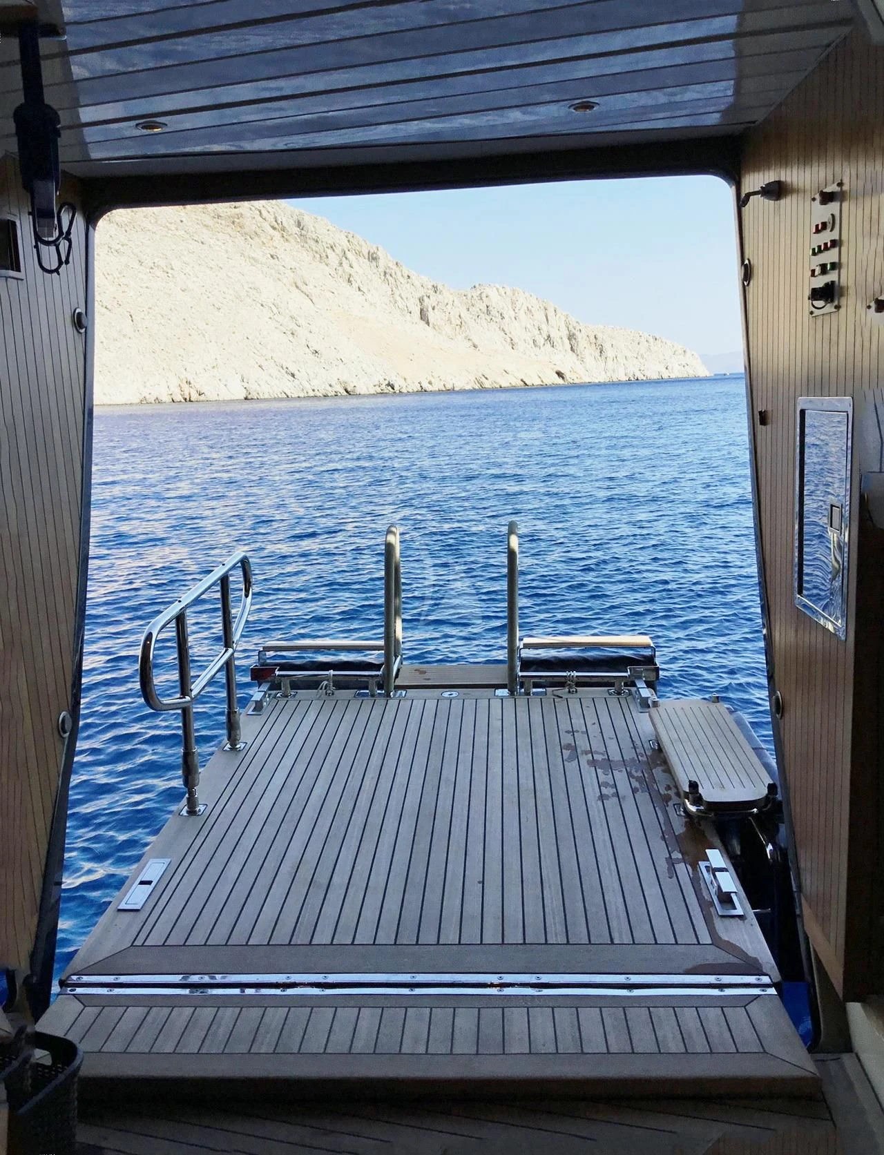 a deck with a view of a beach and a hill aboard LA LUNA Yacht for Sale