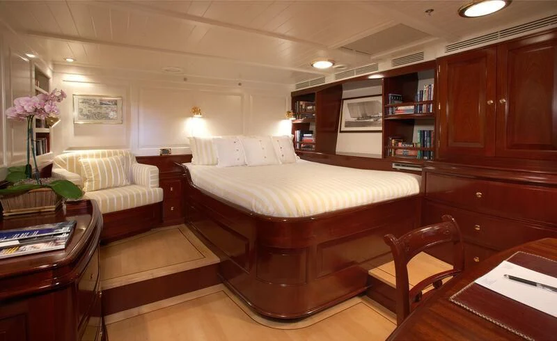 a bedroom with a bed and a desk aboard WINDROSE OF AMSTERDAM Yacht for Sale