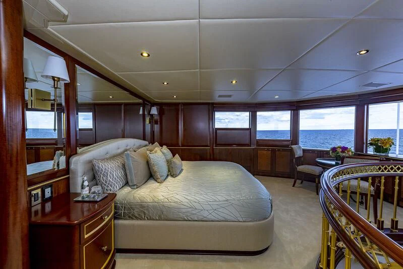 a bedroom with a bed and a table aboard STARSHIP Yacht for Charter