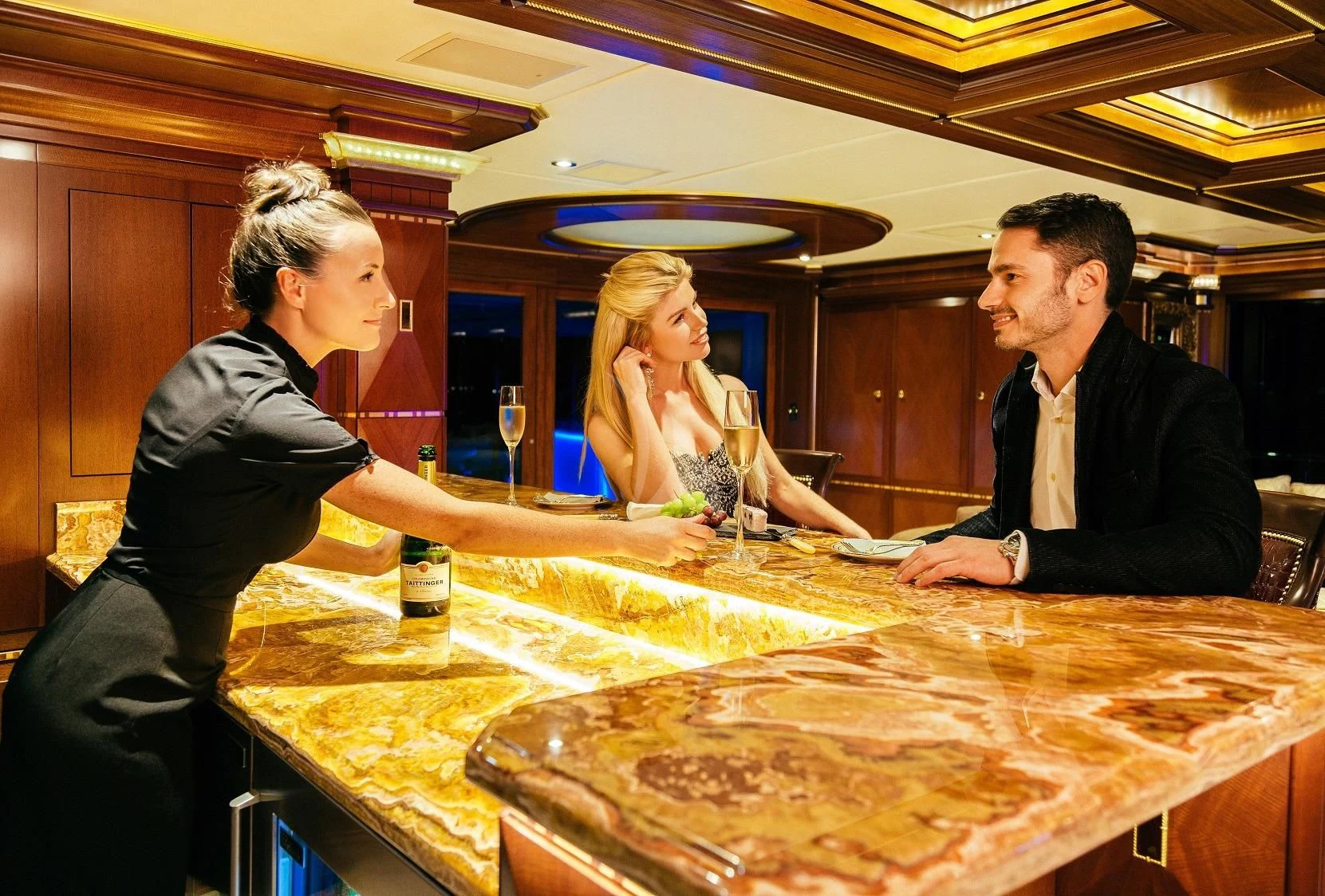 a man and a woman looking at a large fish in a tank aboard STARSHIP Yacht for Charter