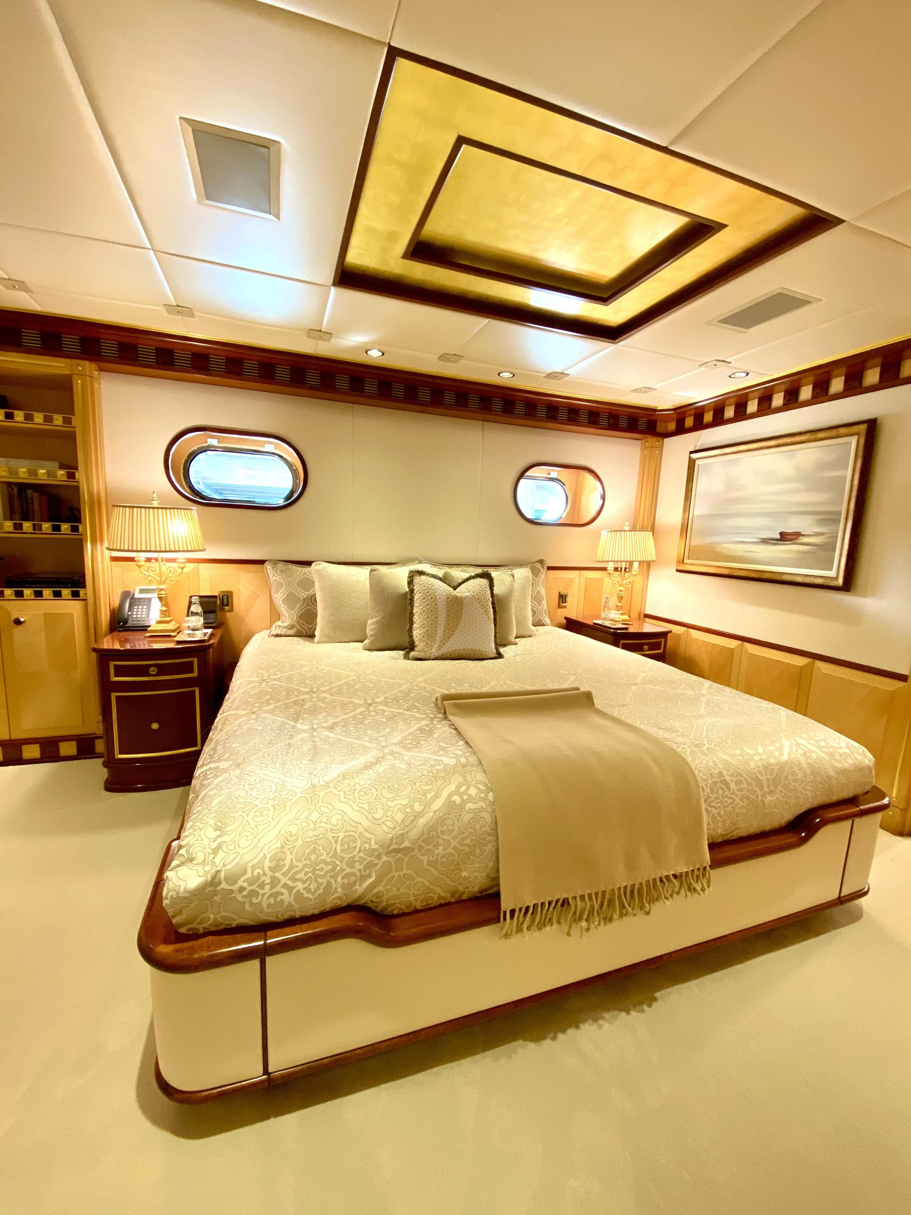 a bedroom with a bed and a mirror aboard STARSHIP Yacht for Charter