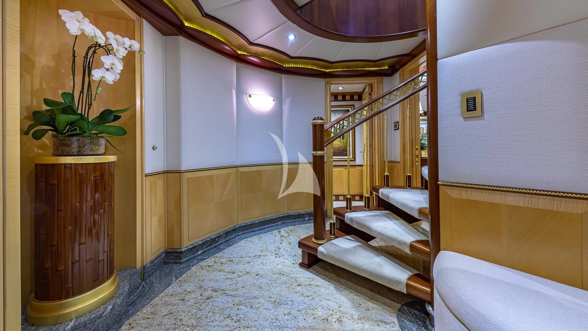 a room with a staircase and a vase of flowers aboard STARSHIP Yacht for Charter