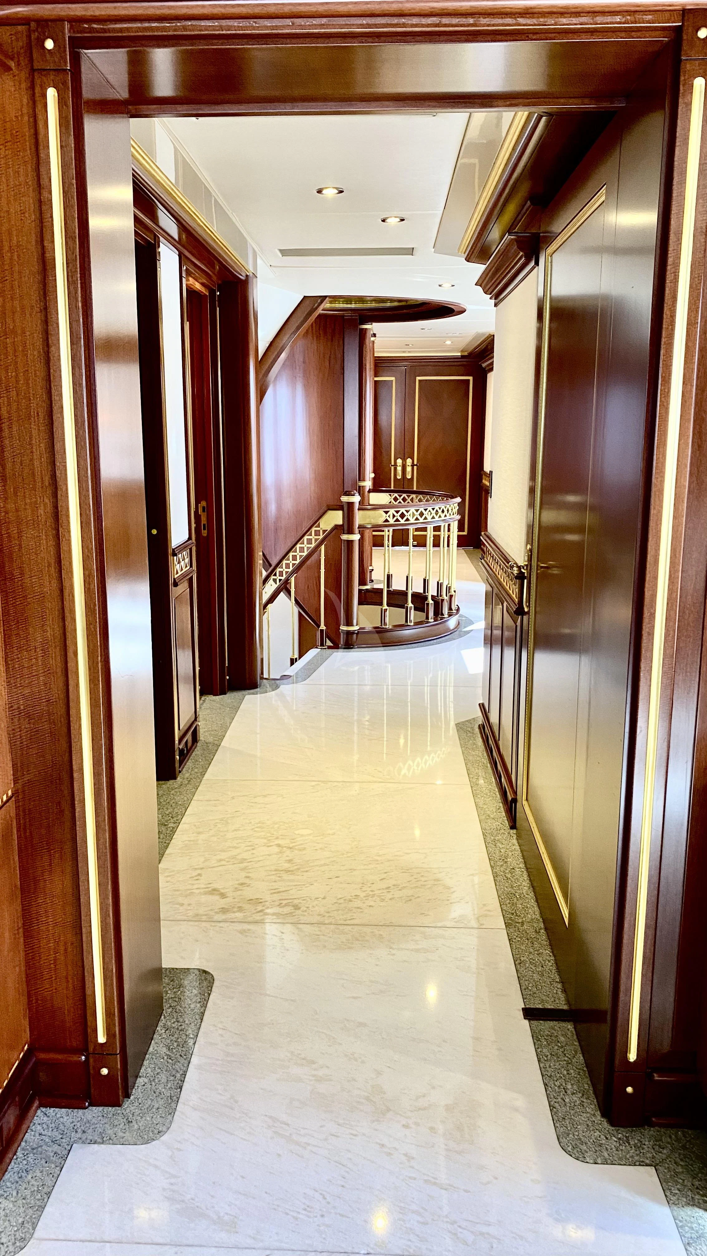 a hallway with a door and a staircase aboard STARSHIP Yacht for Charter