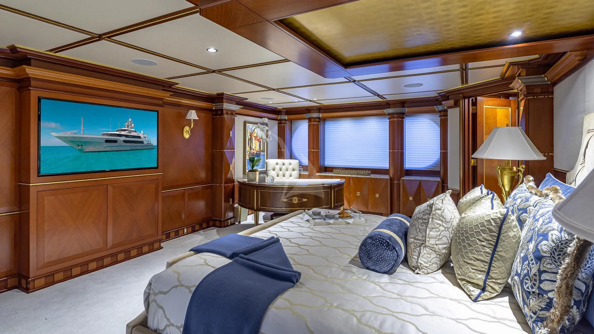a room with a bed and a television aboard STARSHIP Yacht for Charter
