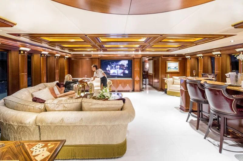a room with a couch and a television aboard STARSHIP Yacht for Charter