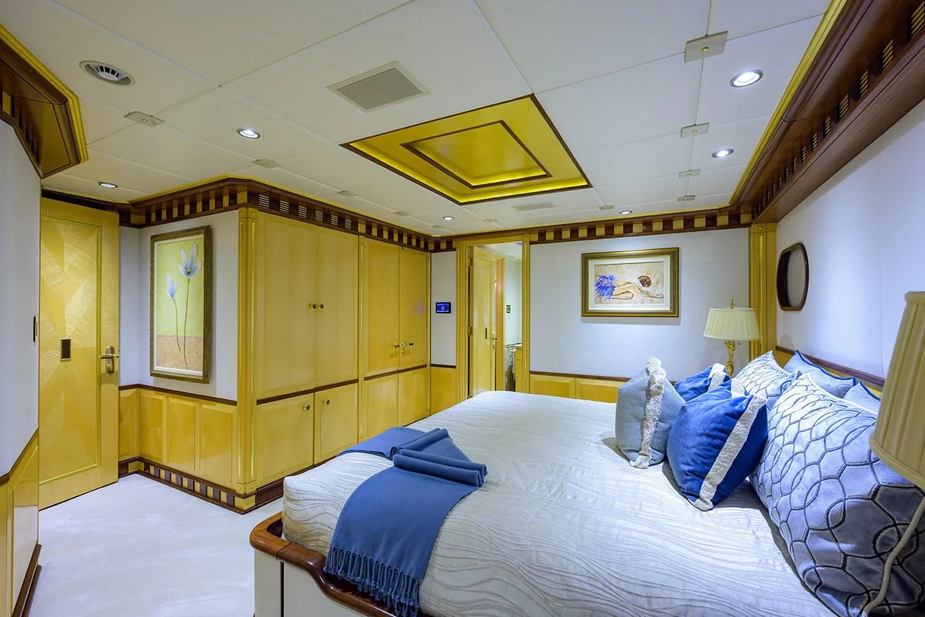 a bedroom with a bed and a wood closet aboard STARSHIP Yacht for Charter