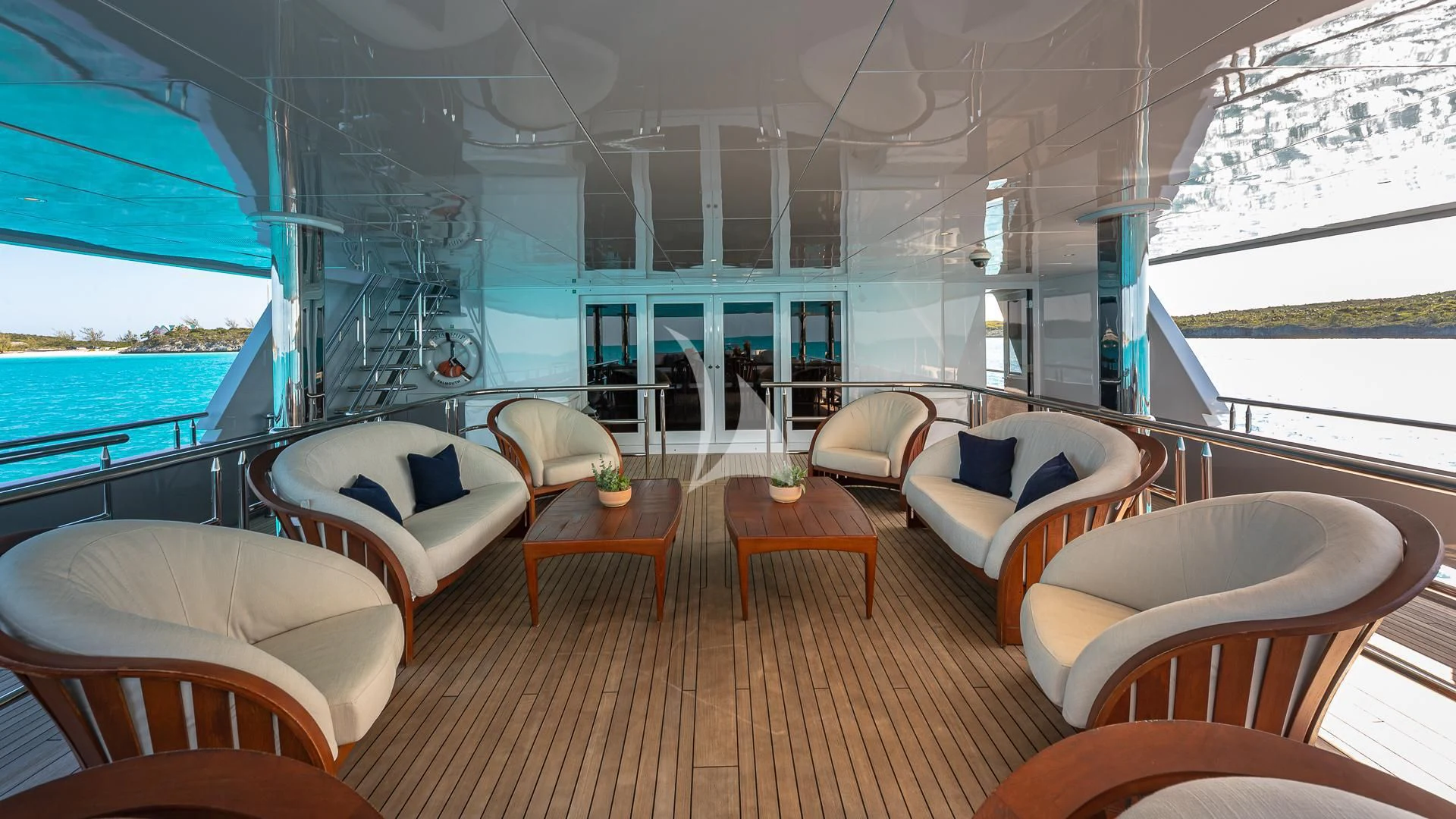 a room with a large window and a table with chairs and a pool aboard STARSHIP Yacht for Charter