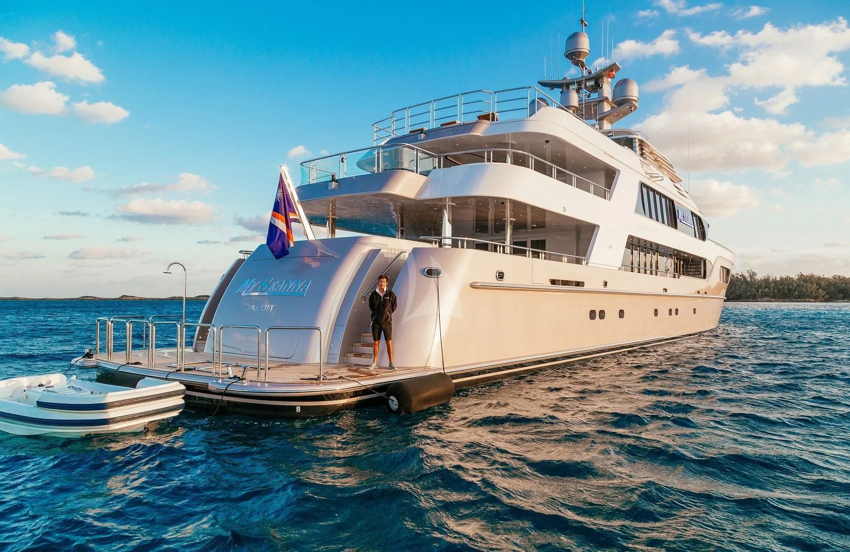 a large white boat with a flag on it aboard STARSHIP Yacht for Charter