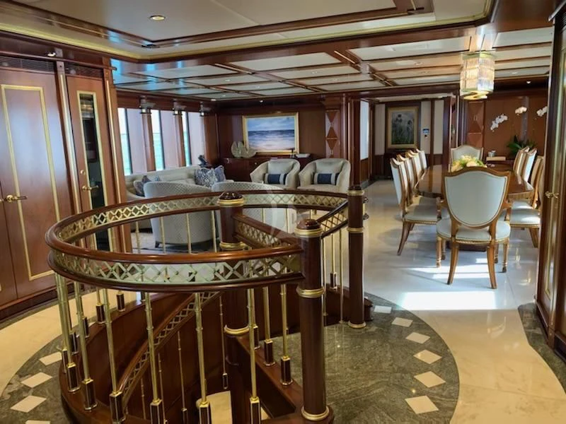 a large room with a table and chairs aboard STARSHIP Yacht for Charter