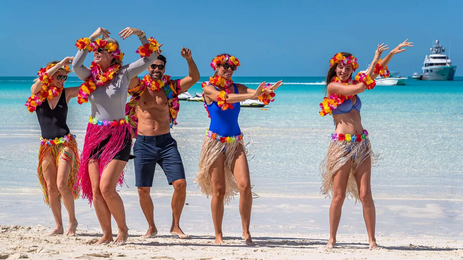 a group of people wearing colorful costumes on a beach aboard STARSHIP Yacht for Charter