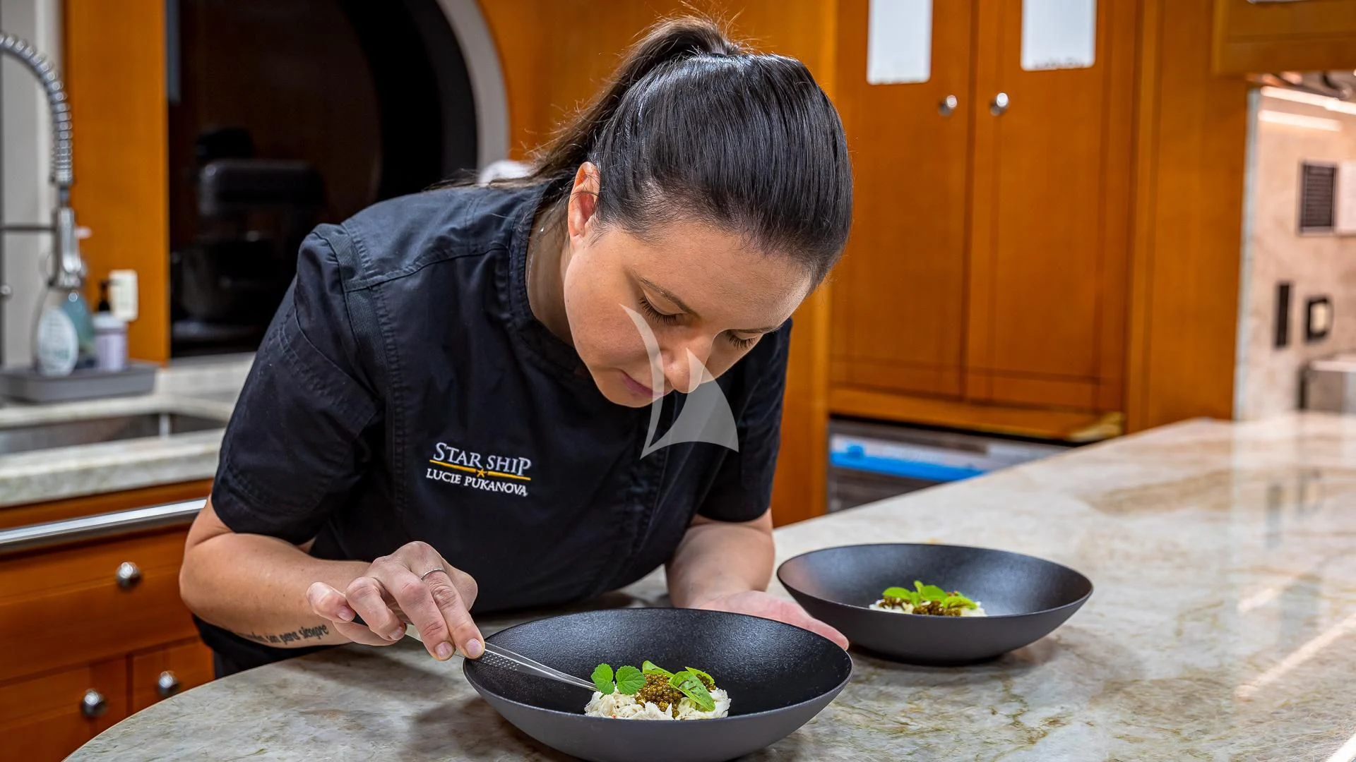 a person cooking in a kitchen aboard STARSHIP Yacht for Charter