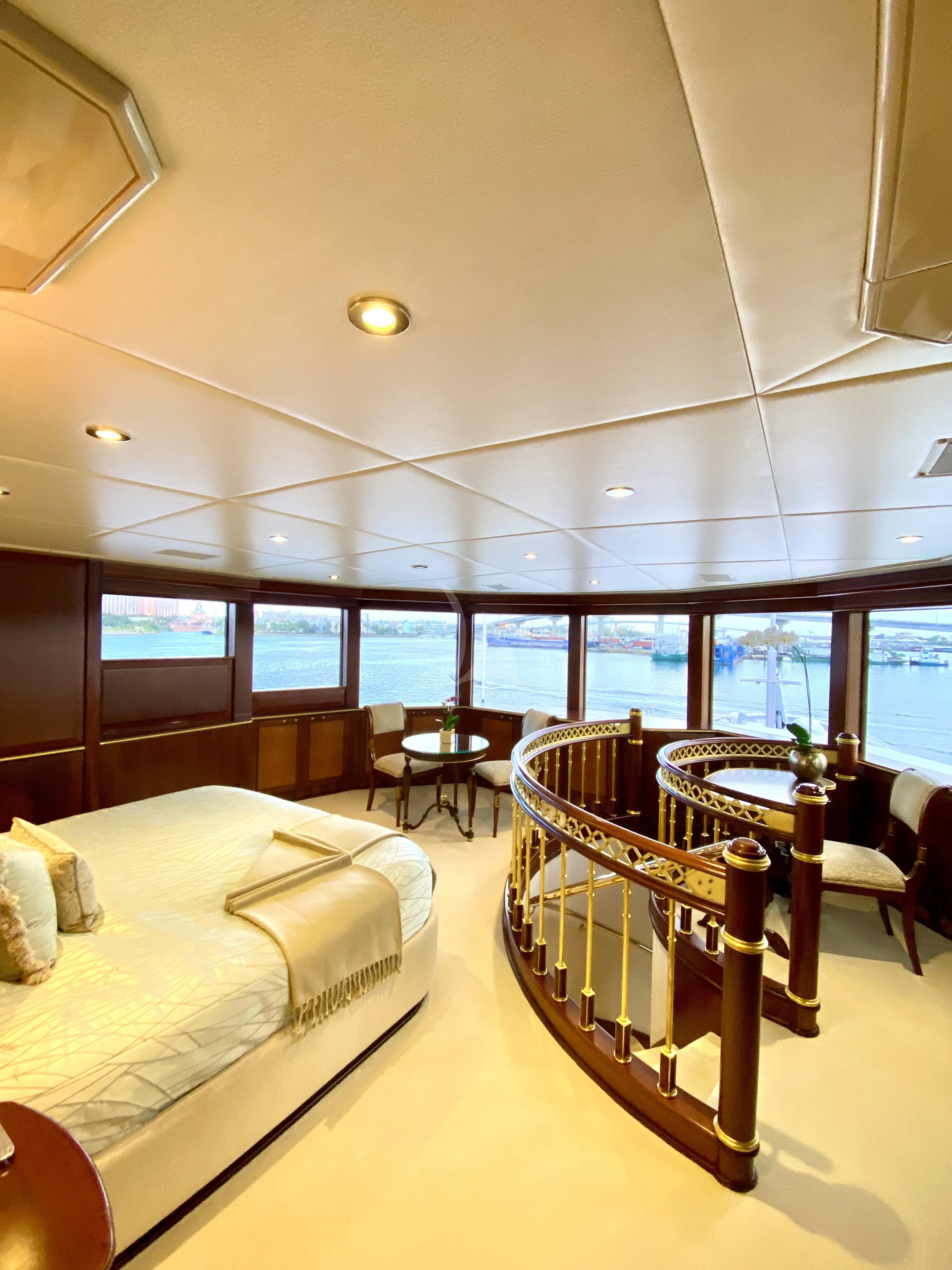 a room with a bed and a table and chairs aboard STARSHIP Yacht for Charter