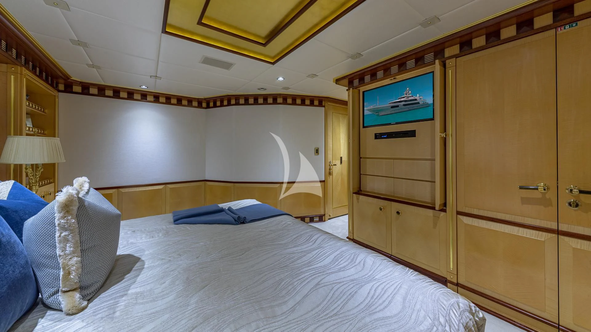 a bed with a television on the wall aboard STARSHIP Yacht for Charter