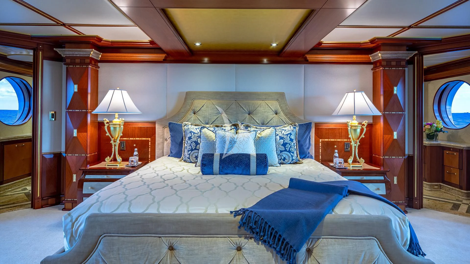a bed with blue sheets aboard STARSHIP Yacht for Charter