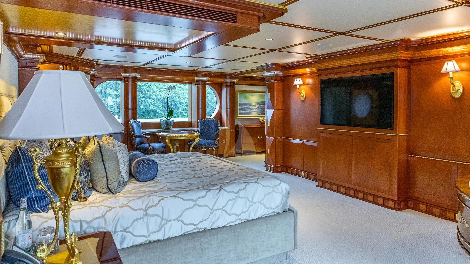 a room with a bed and a television aboard STARSHIP Yacht for Charter