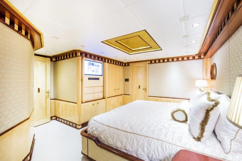 a bedroom with a bed and a desk aboard STARSHIP Yacht for Charter