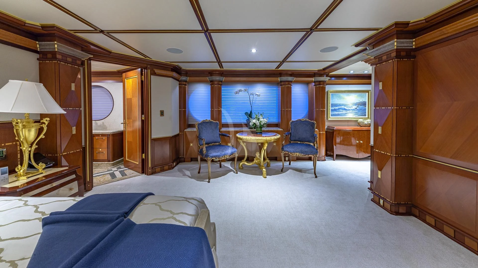 a room with a bed and a table and chairs aboard STARSHIP Yacht for Charter