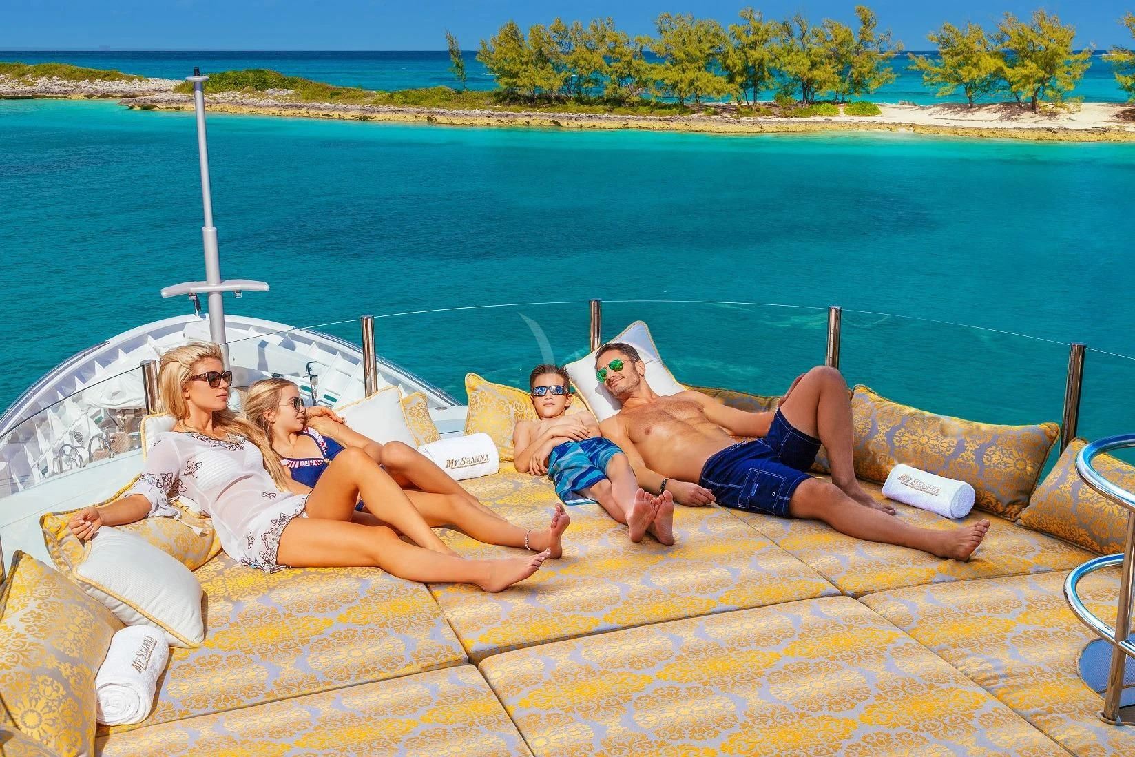 a group of people lying on a lounge chair on a beach aboard STARSHIP Yacht for Charter