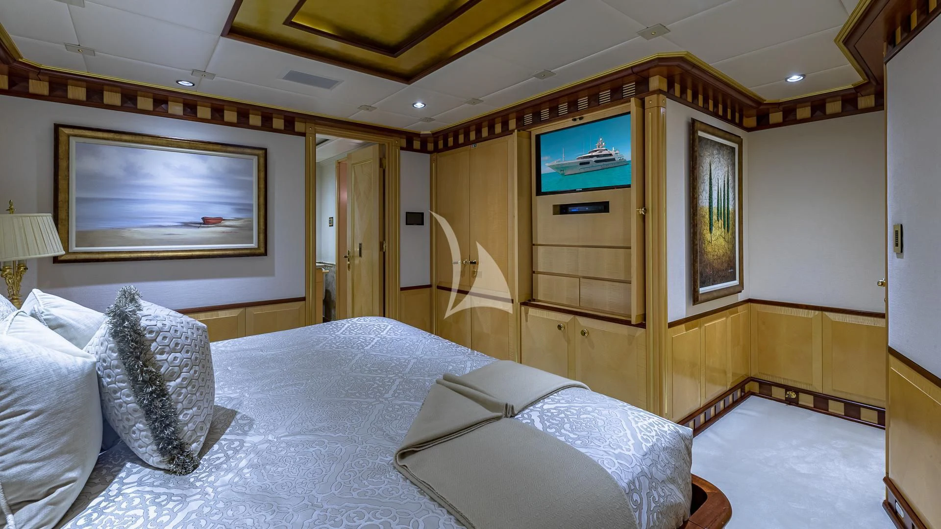 a room with a bed and a television on the wall aboard STARSHIP Yacht for Charter