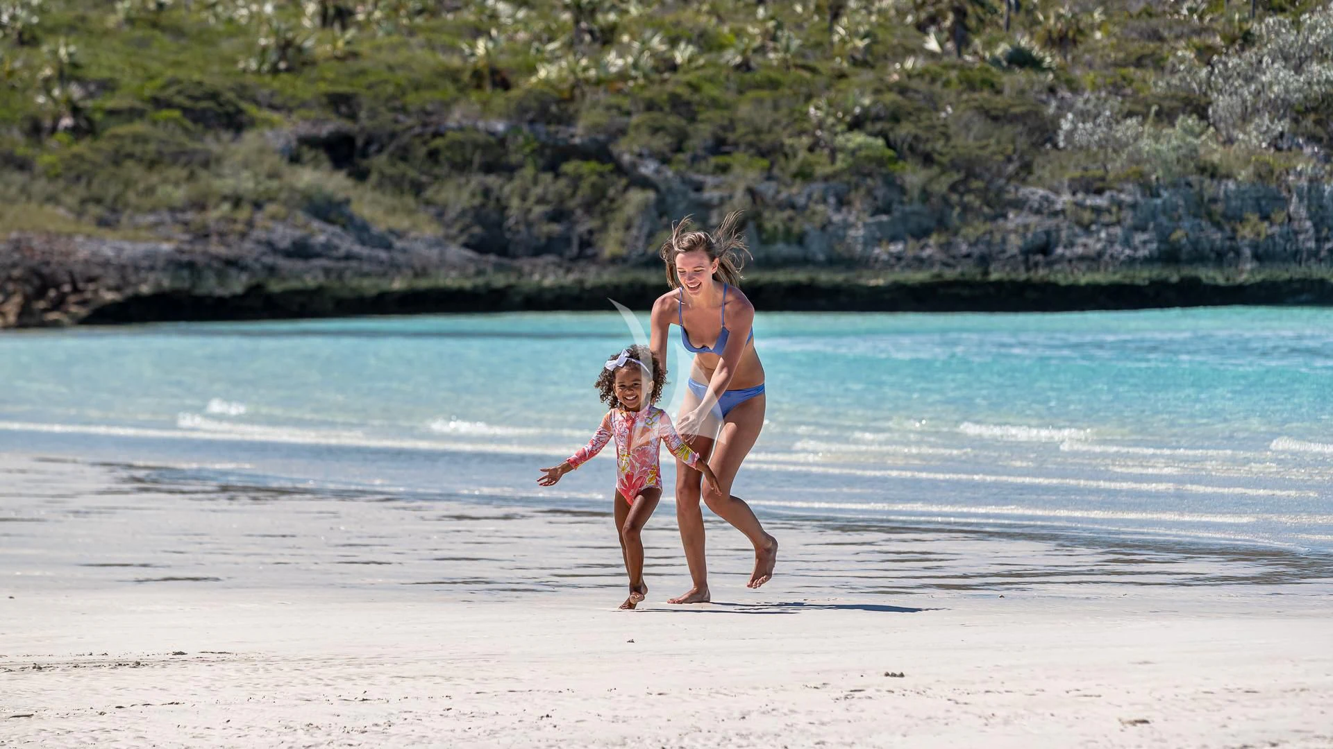 a person and a girl walking on a beach aboard STARSHIP Yacht for Charter