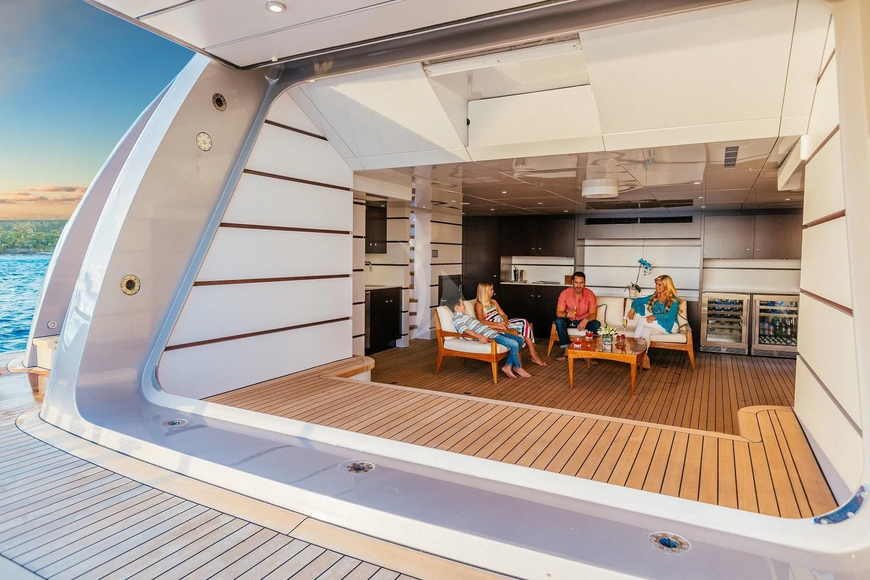 a group of people sitting at a table on a deck aboard STARSHIP Yacht for Charter