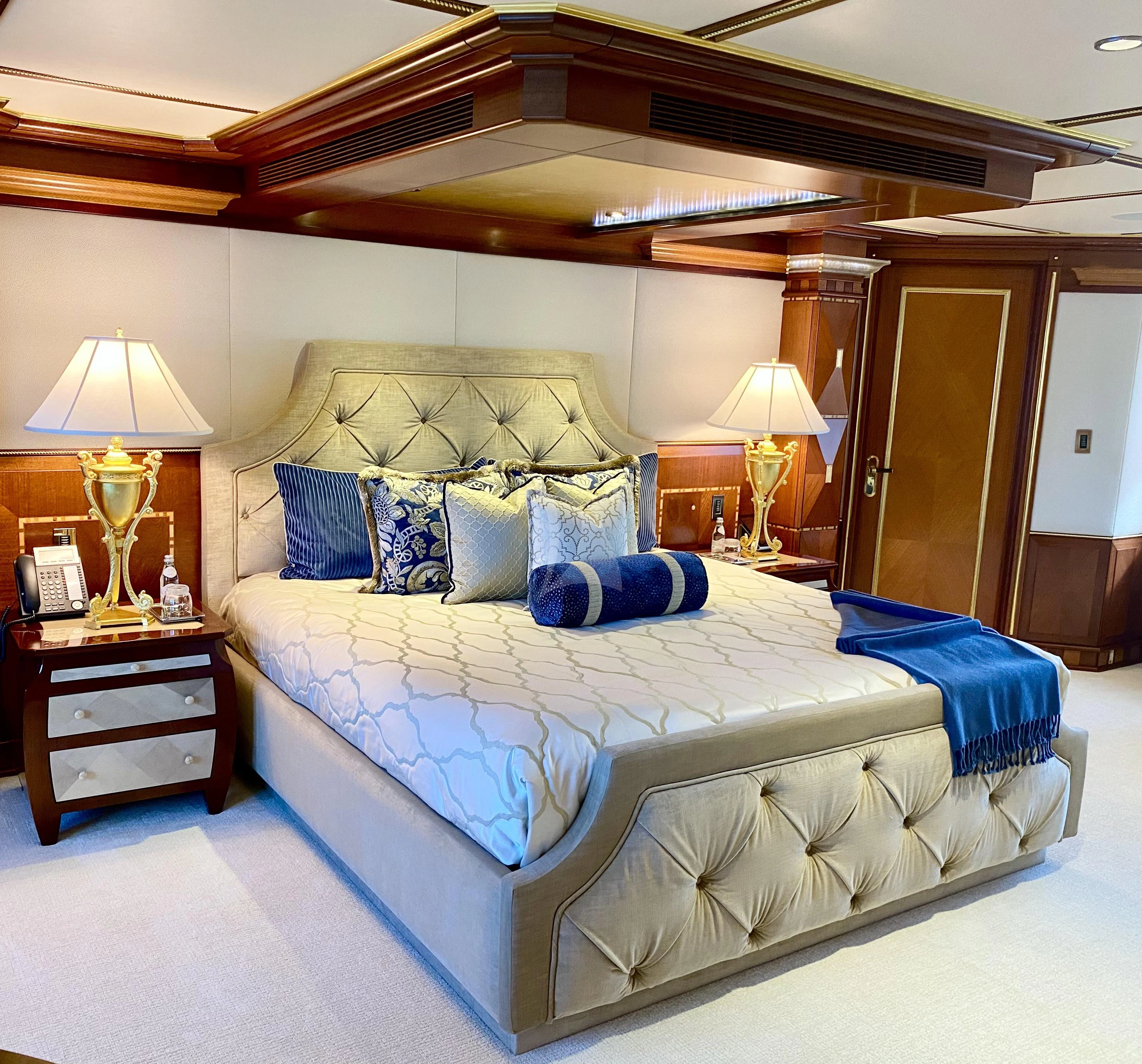 a bed with blue sheets aboard STARSHIP Yacht for Charter
