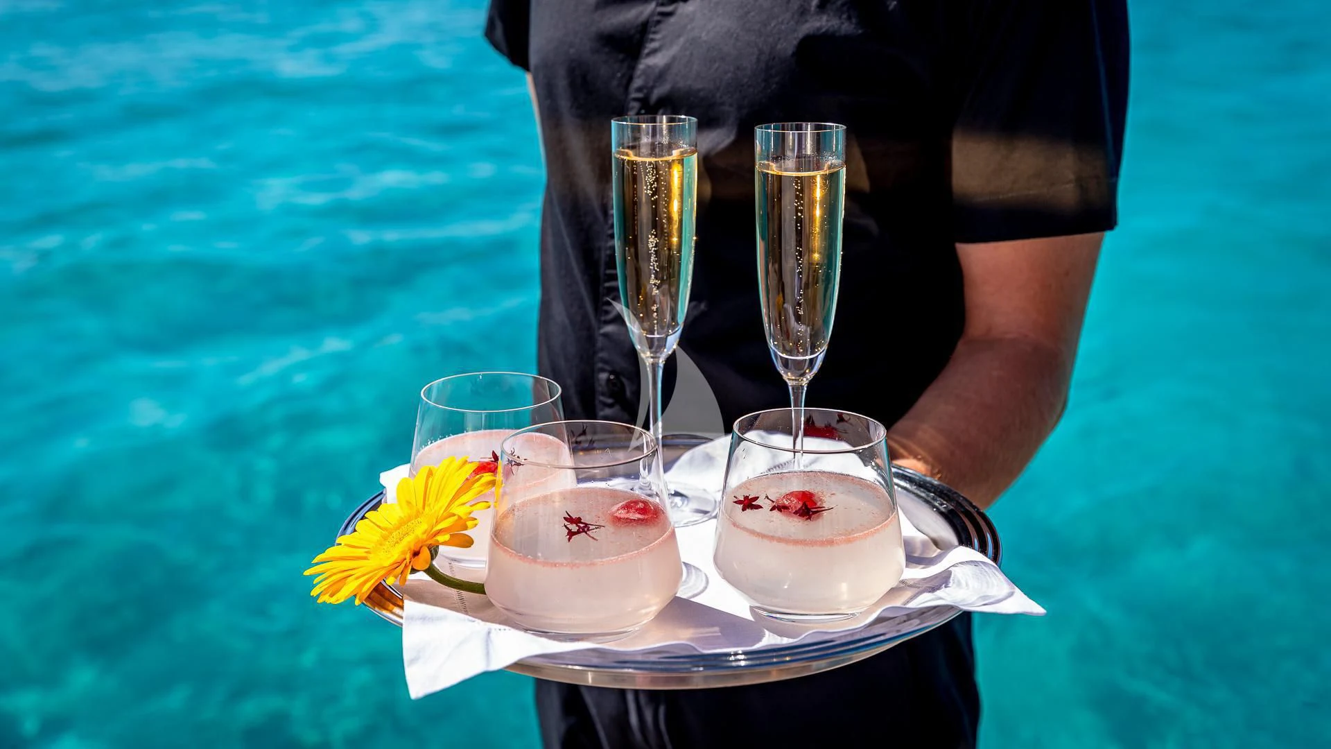 a person pouring liquid into a glass aboard STARSHIP Yacht for Charter