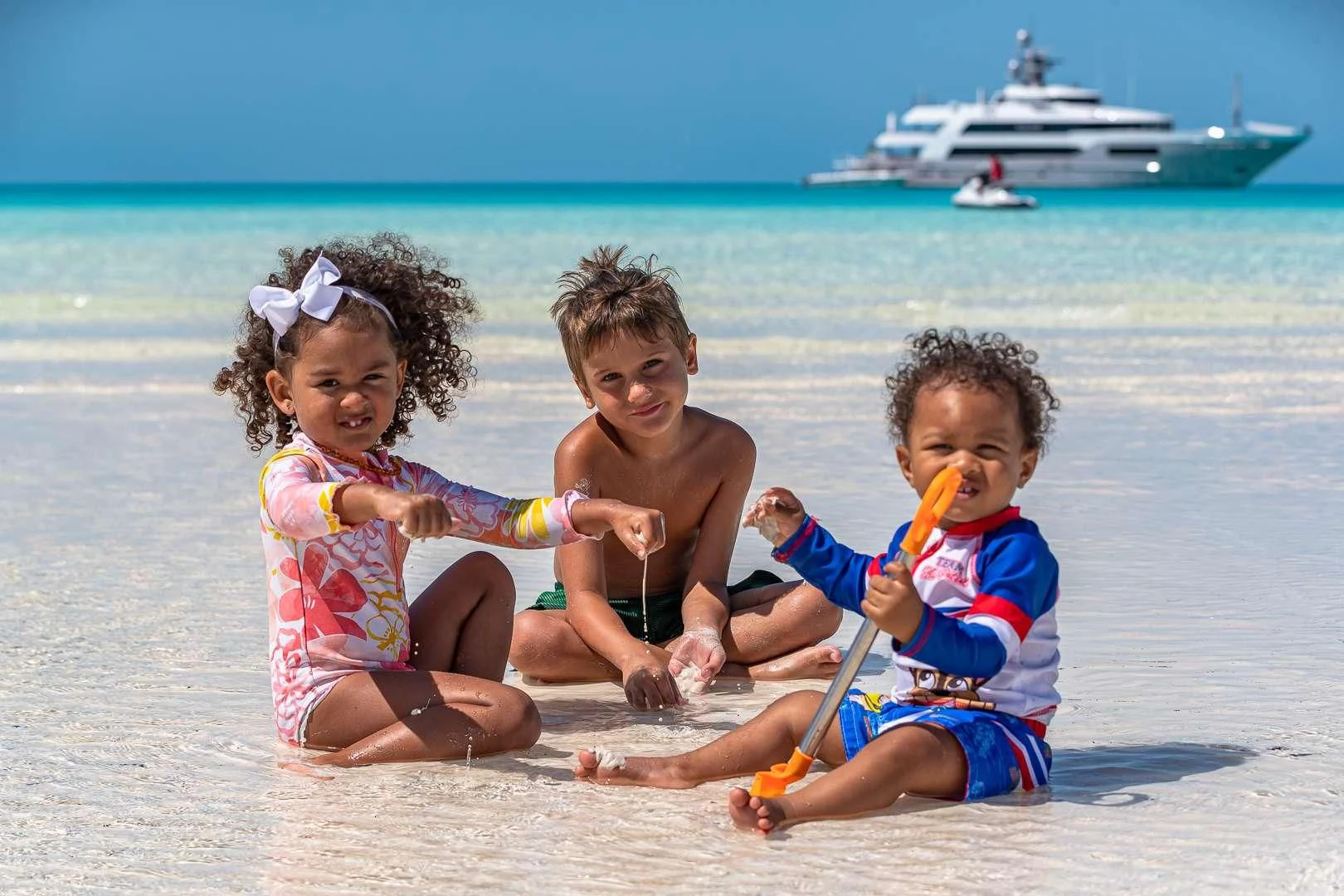 a group of children playing on the beach aboard STARSHIP Yacht for Charter