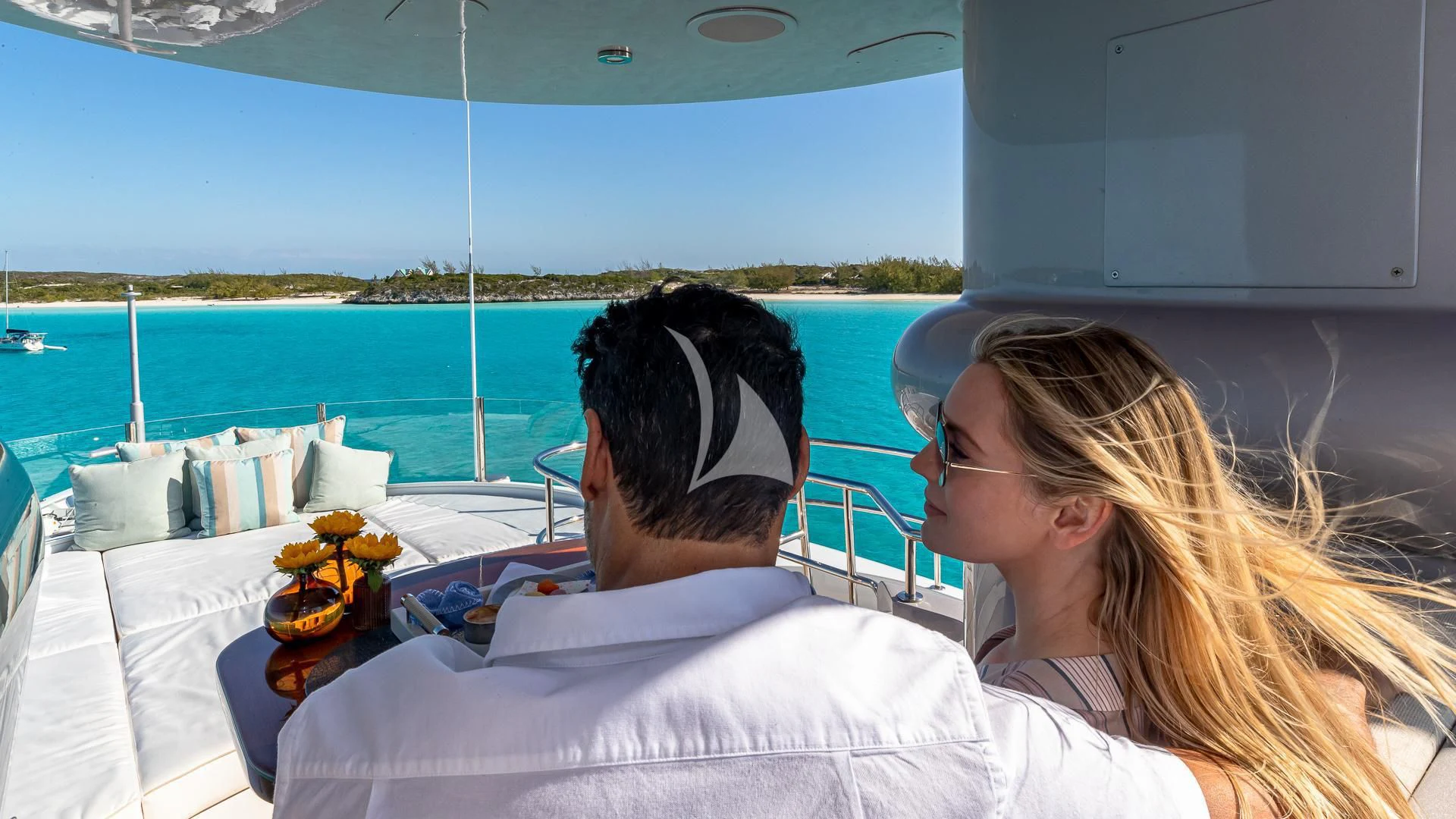 a man and woman sitting on a boat with a drink and a pool aboard STARSHIP Yacht for Charter