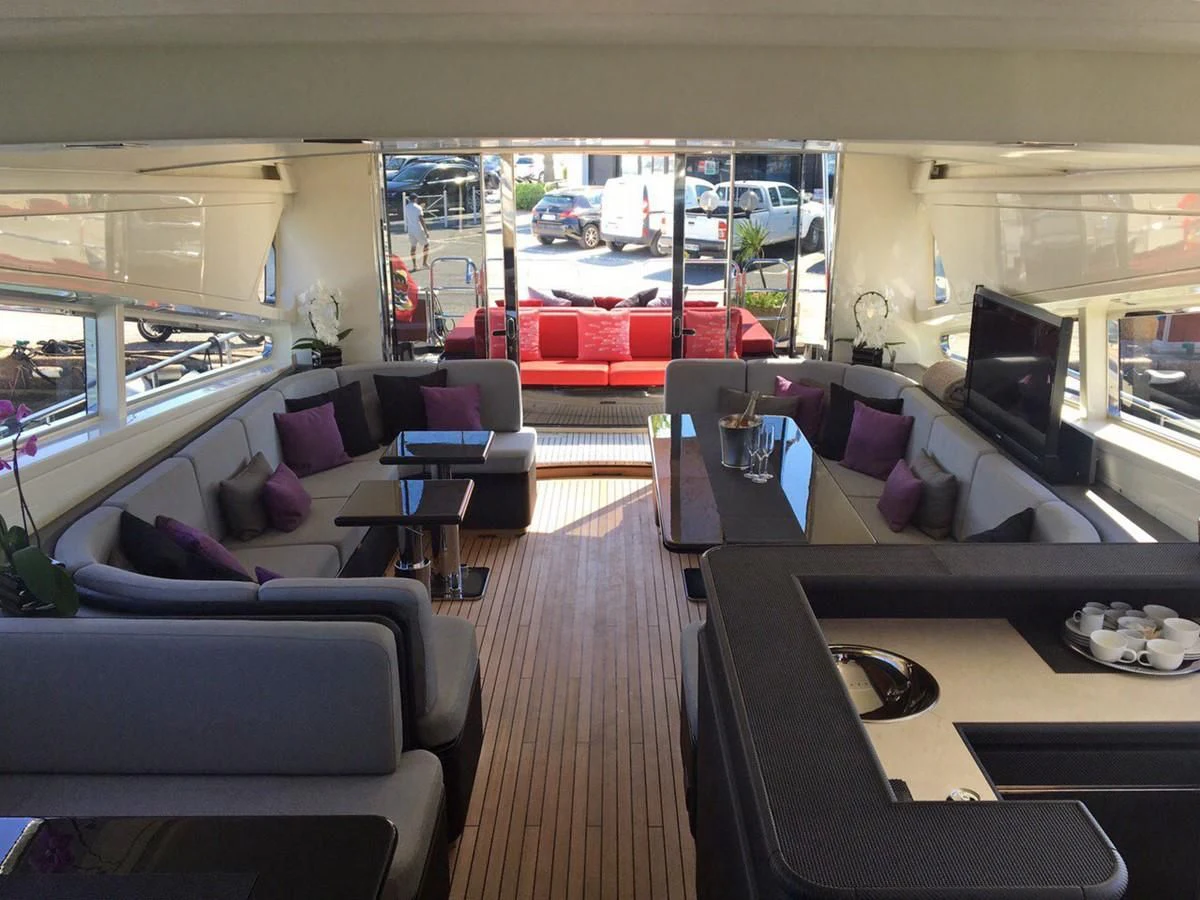 a room with a couch and a table with chairs and a window aboard MYSVEN Yacht for Sale