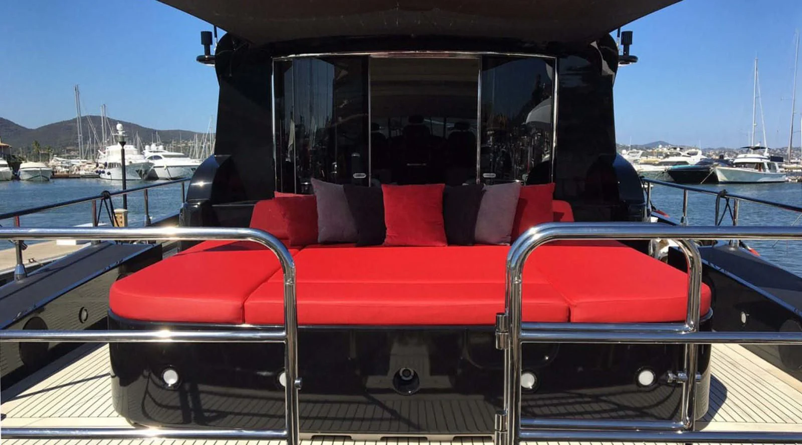a red and black boat on a deck with other boats in the water aboard MYSVEN Yacht for Sale