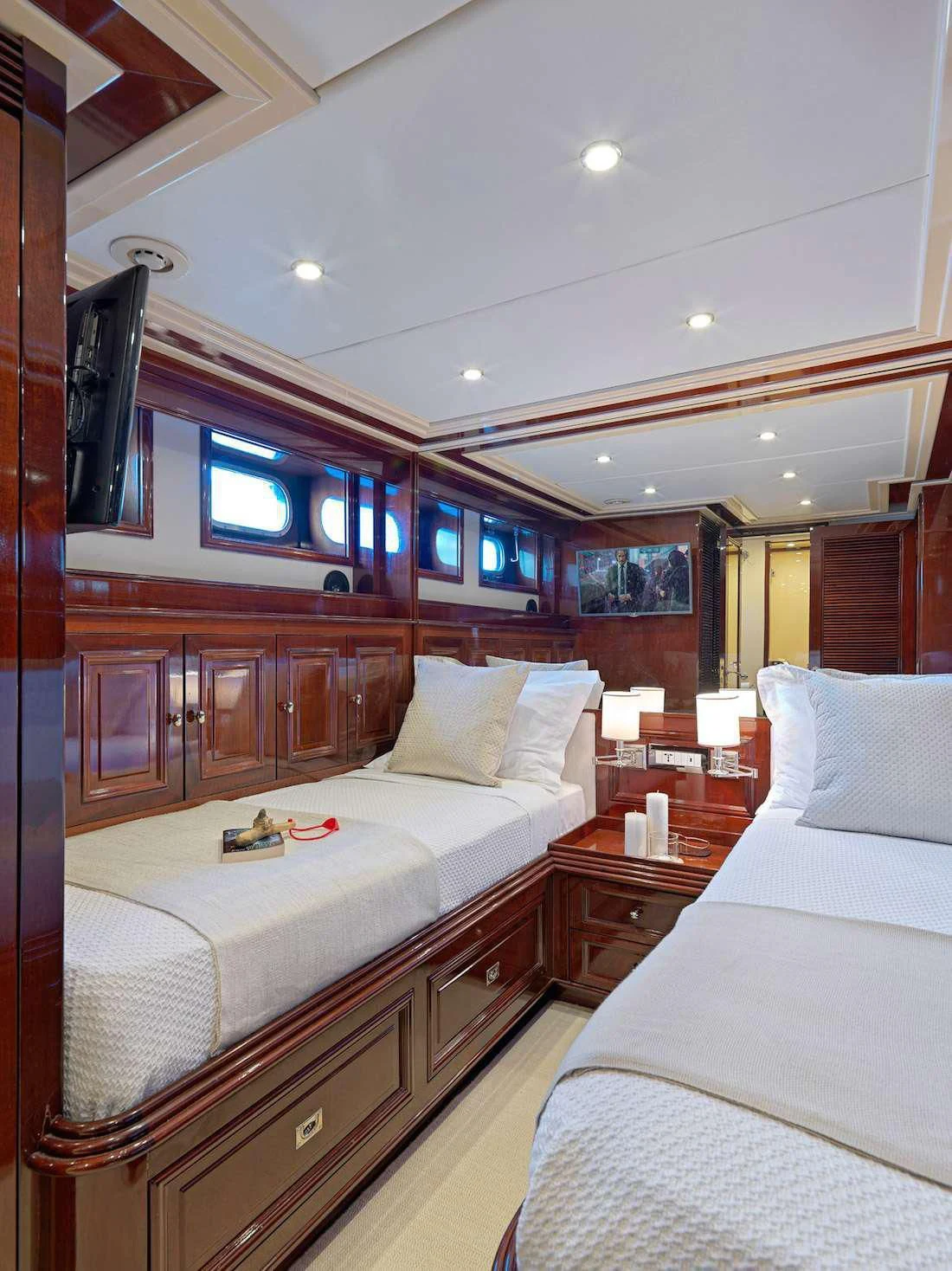 a room with a bed and a television aboard MIA ZOI Yacht for Charter