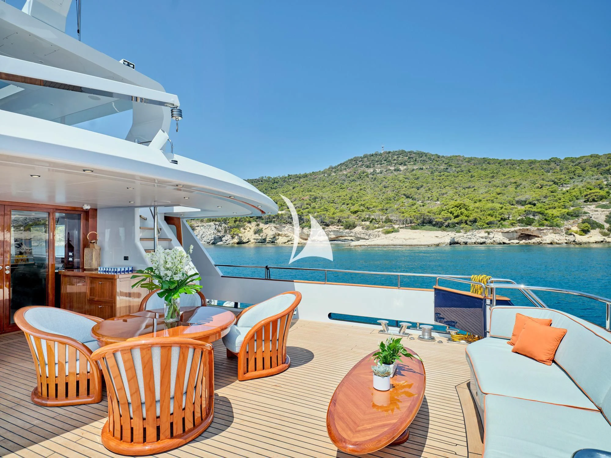 a patio with tables and chairs on it next to a large body of water aboard MIA ZOI Yacht for Charter