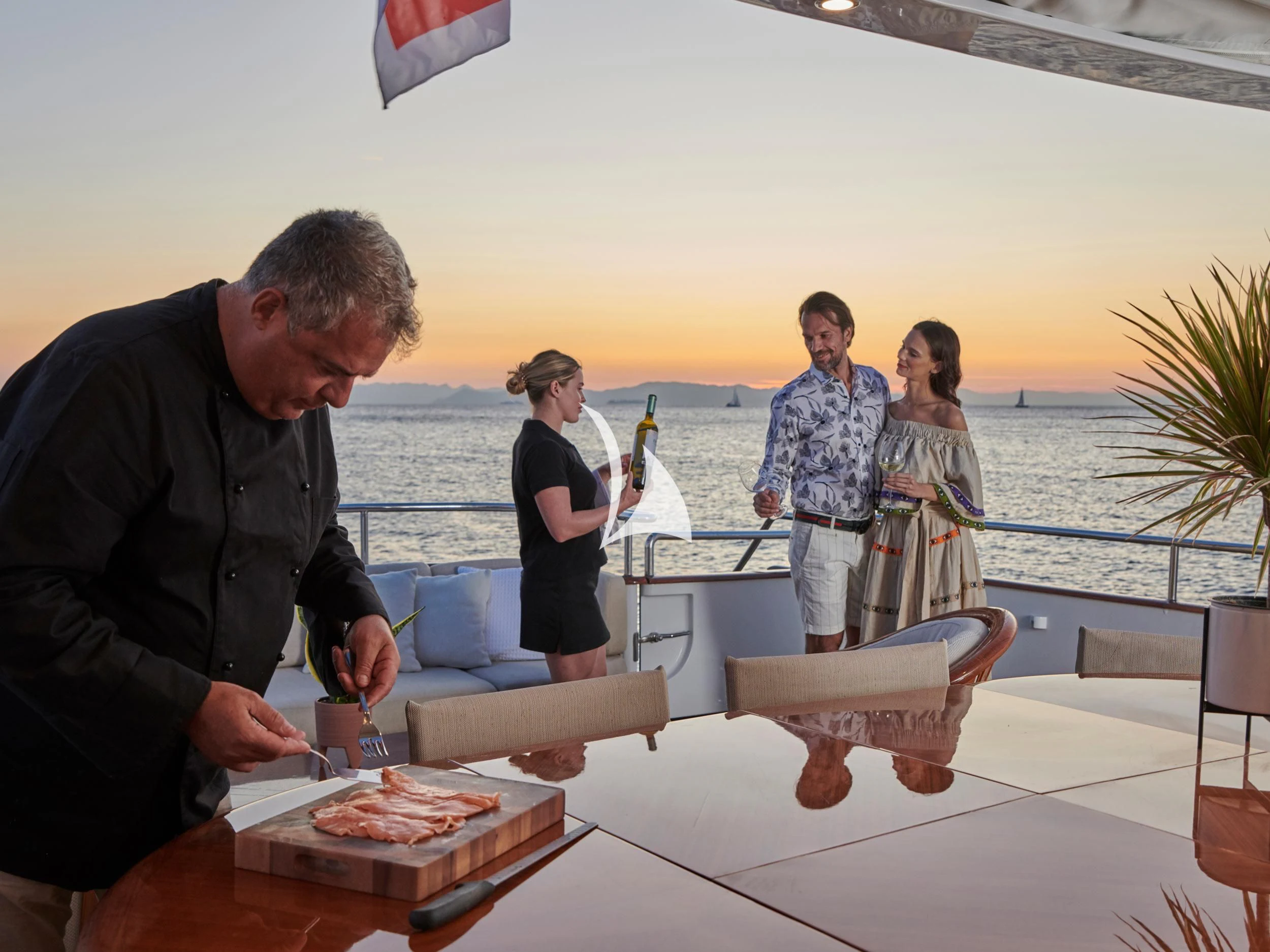 a group of people standing around a table with food on it aboard MIA ZOI Yacht for Charter
