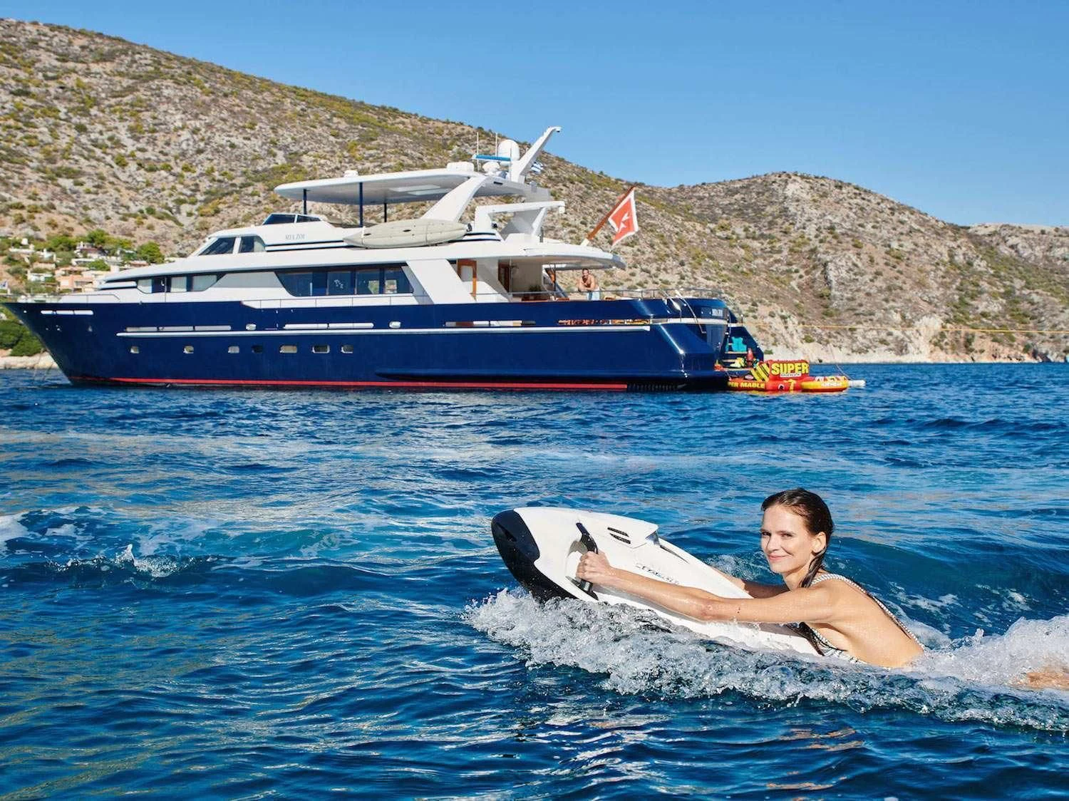 a person surfing in the sea aboard MIA ZOI Yacht for Charter