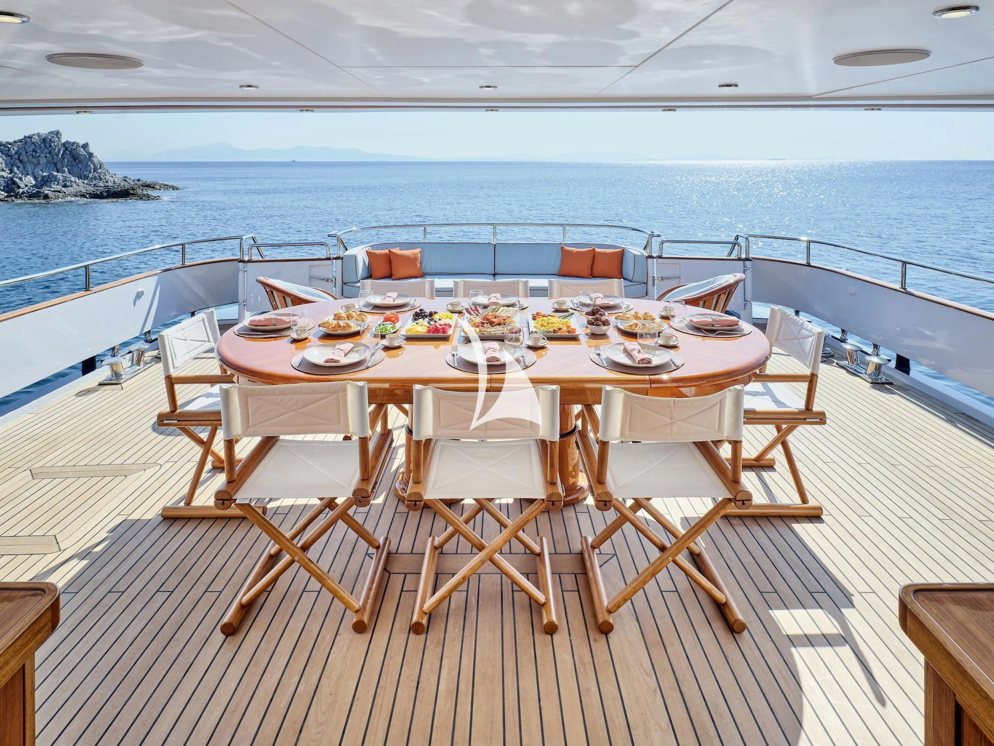 a table set for a meal on a deck overlooking the ocean aboard MIA ZOI Yacht for Charter