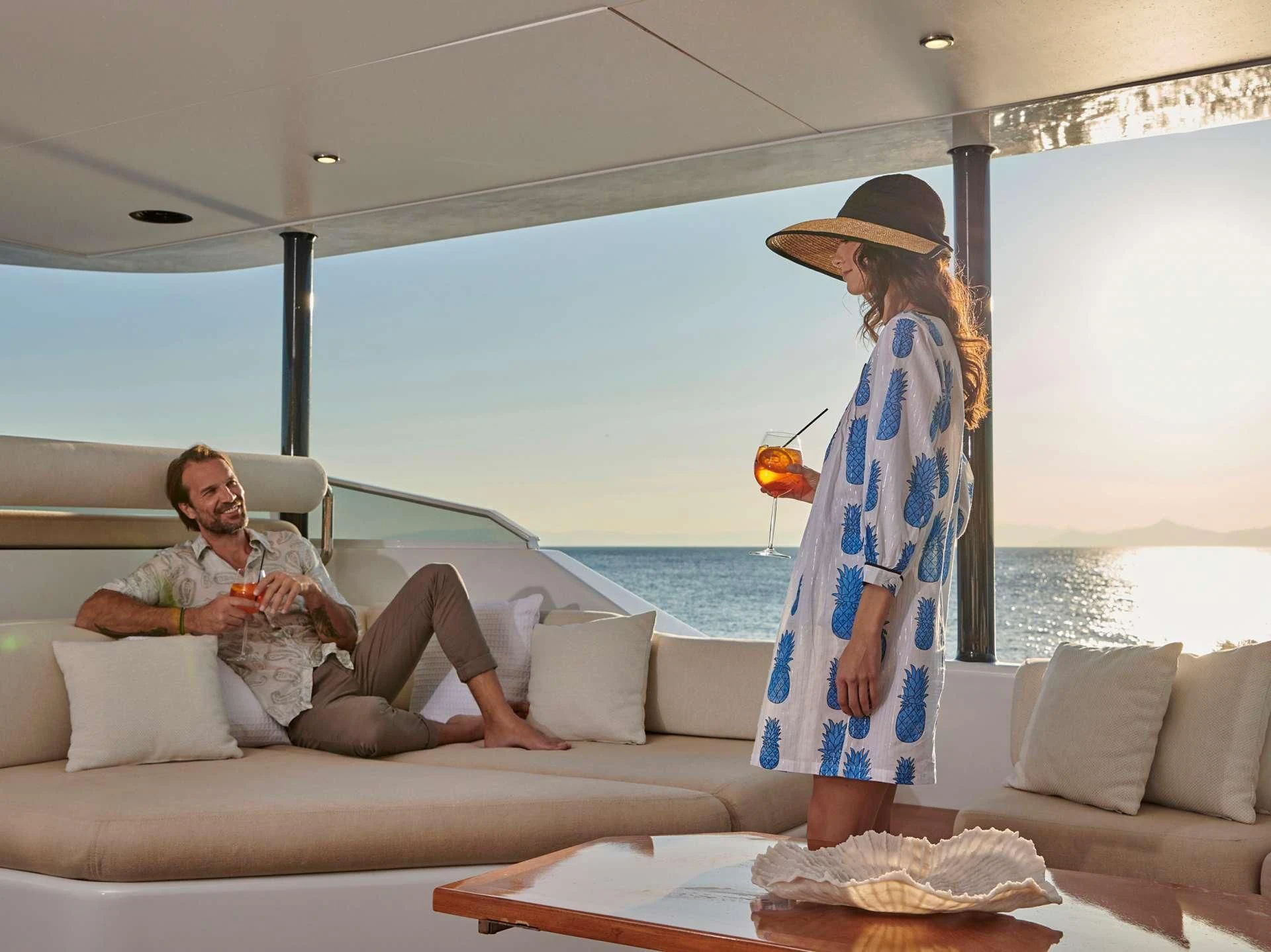 a woman sitting on a couch with a man sitting on a couch aboard MIA ZOI Yacht for Charter