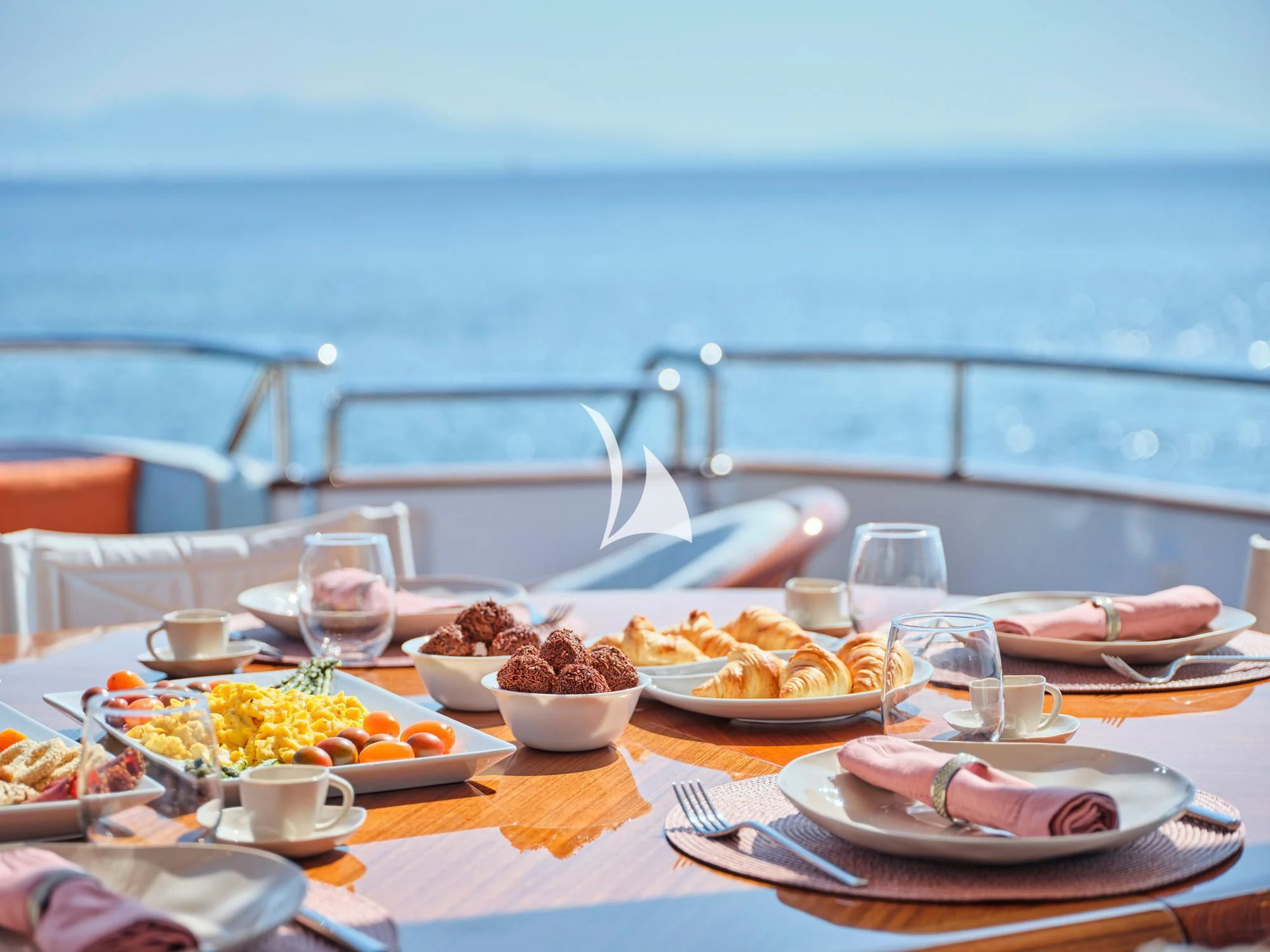 a table with plates of food and glasses on it aboard MIA ZOI Yacht for Charter