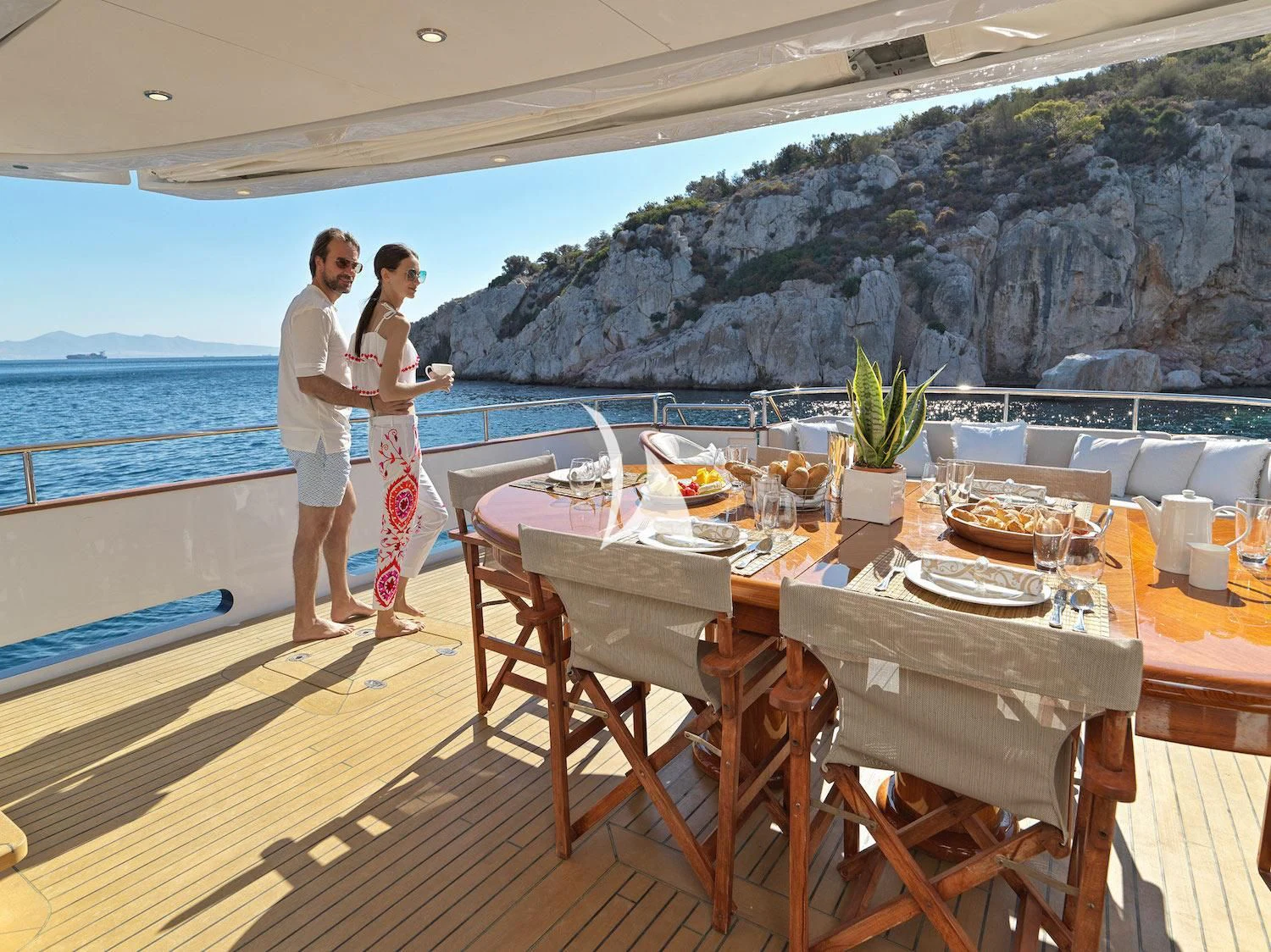 a couple of people on a deck overlooking a body of water aboard MIA ZOI Yacht for Charter