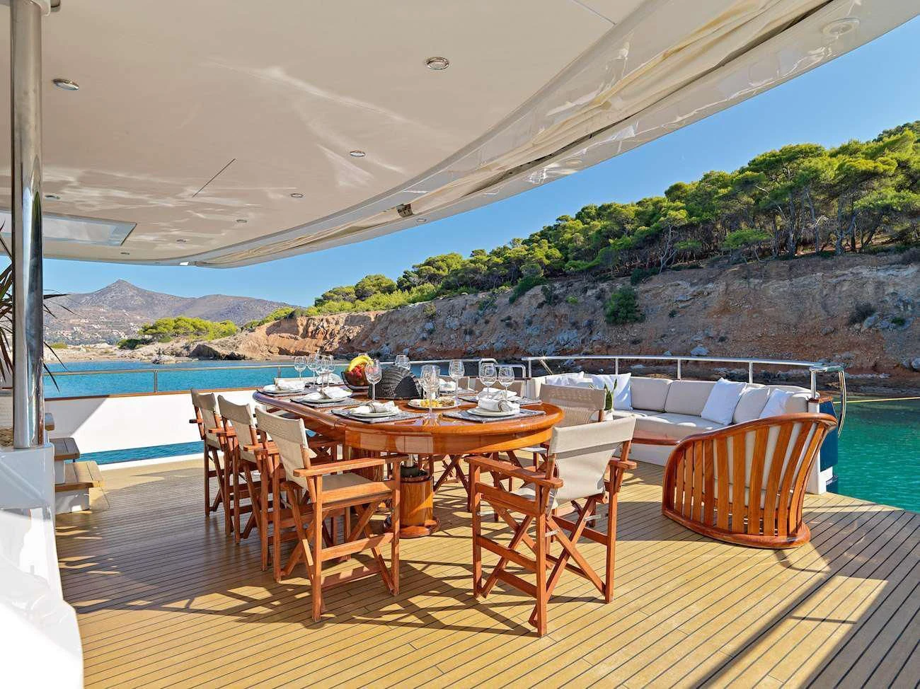 a table set for a meal on a deck overlooking a body of water aboard MIA ZOI Yacht for Charter
