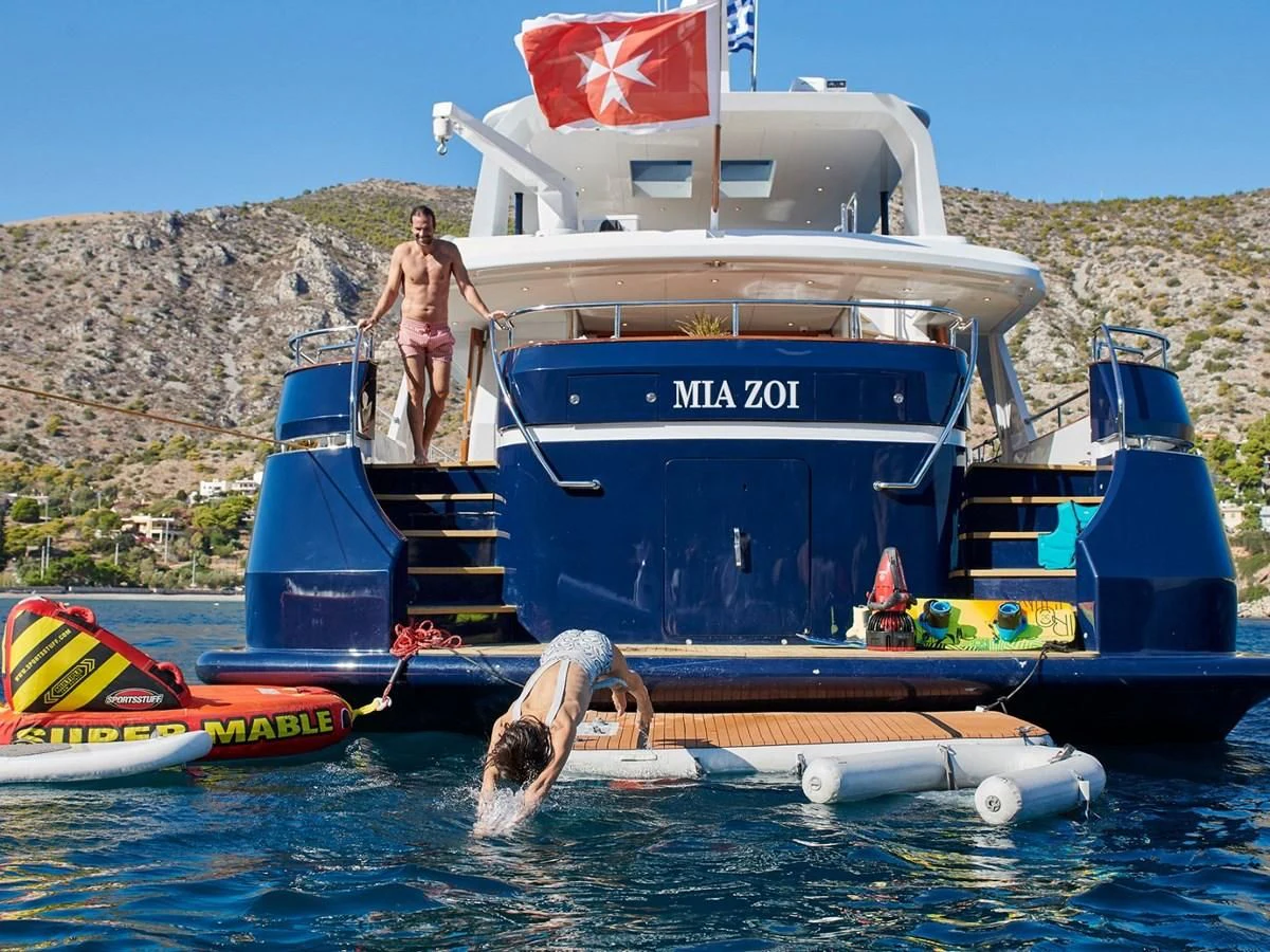 a boat with a flag on the front aboard MIA ZOI Yacht for Charter