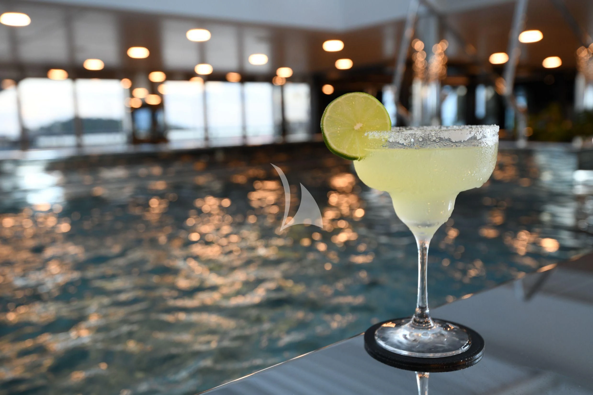 a glass with a lime wedge on a table with a lime wedge aboard SCENIC ECLIPSE Yacht for Sale