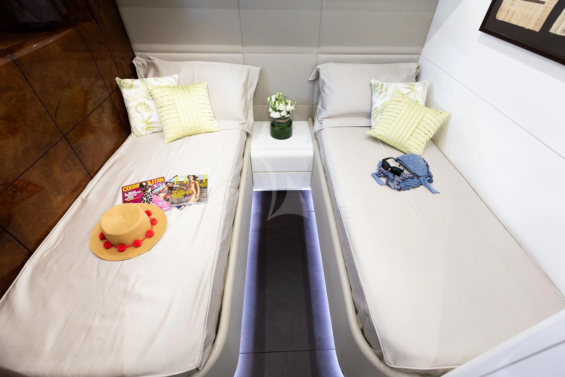 a white bed with a white bed and a white table with a flower on it aboard CAMILLA A Yacht for Sale