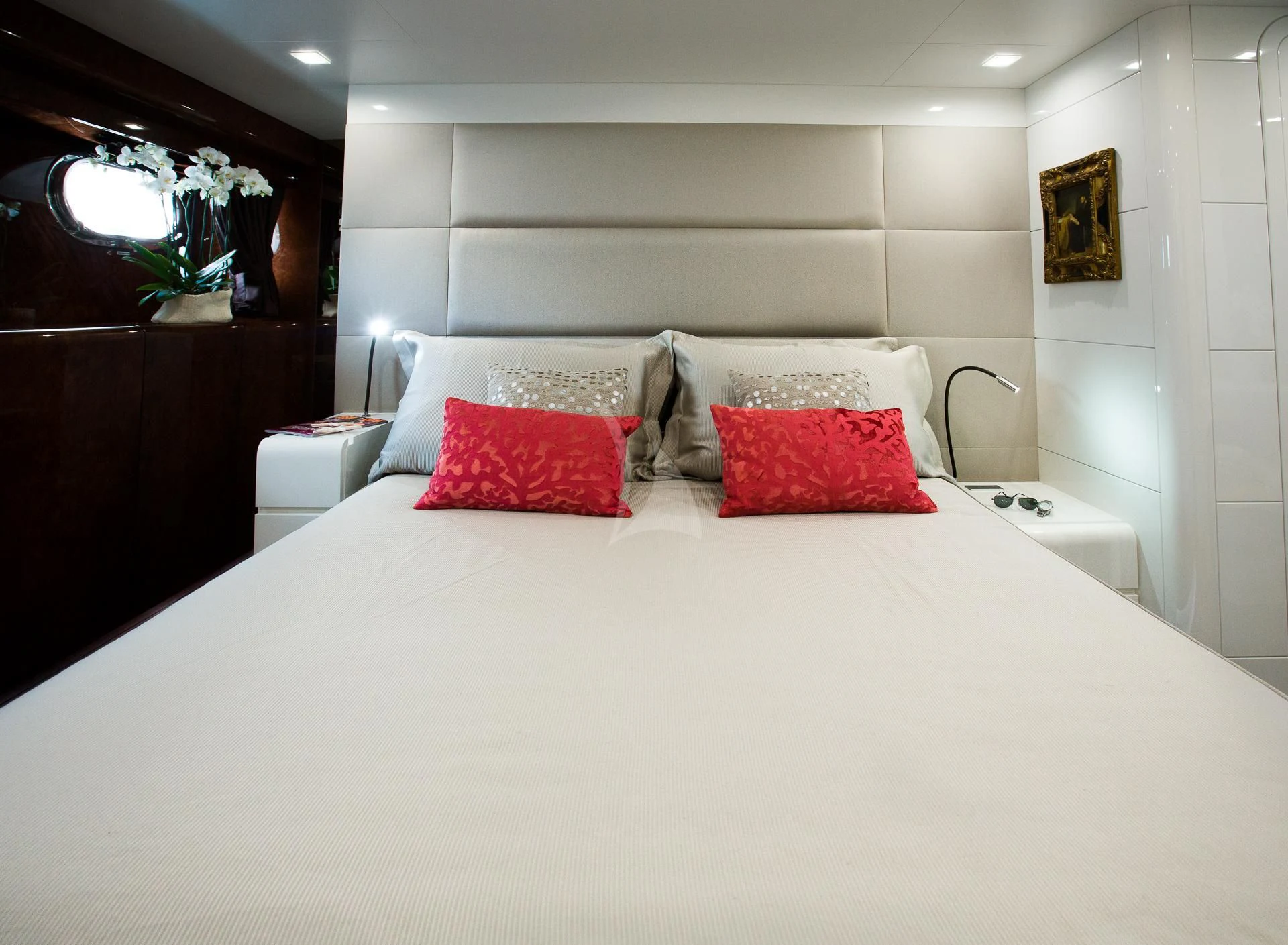 a bed with red pillows aboard CAMILLA A Yacht for Sale
