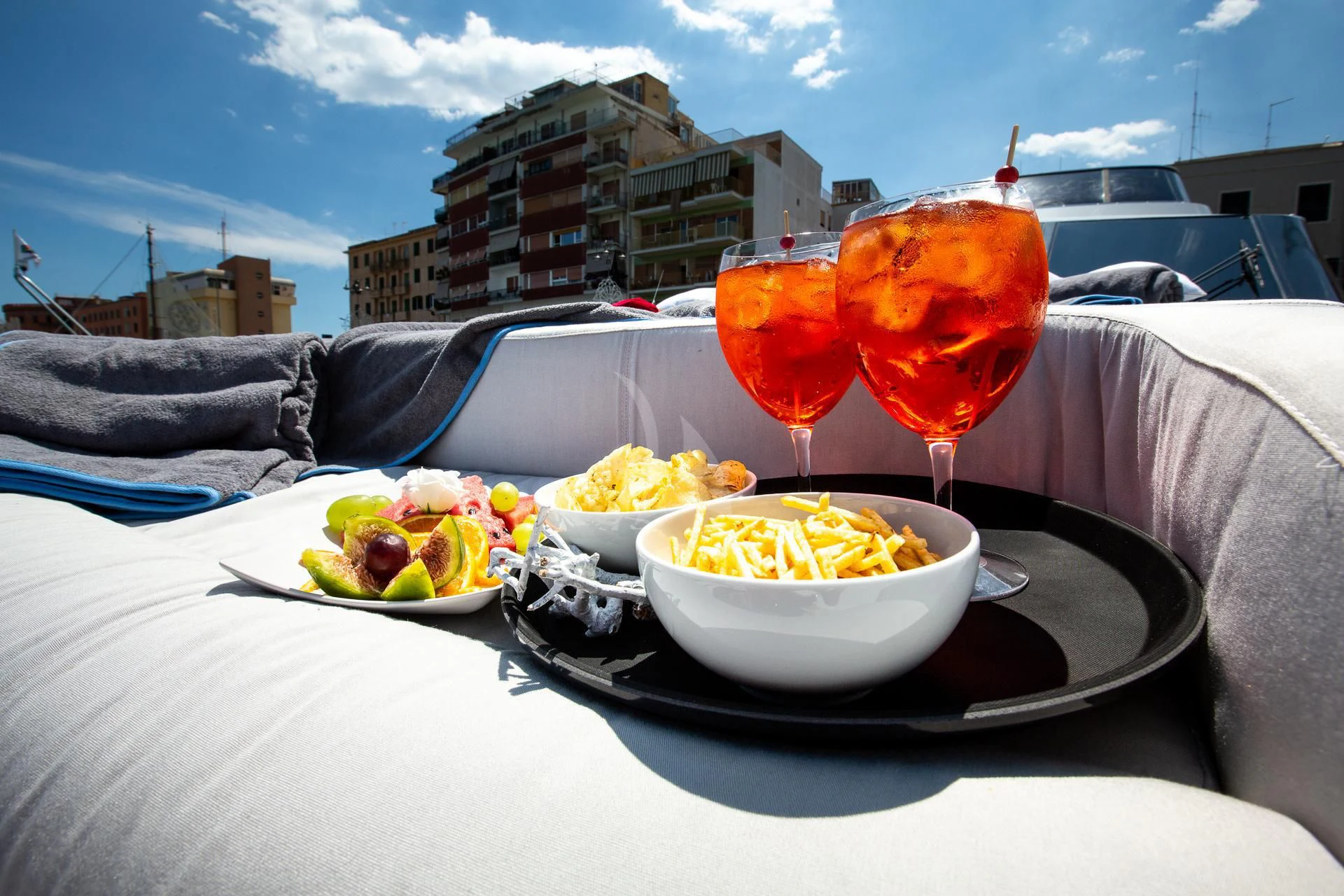 a person lying on a couch with a table of food and drinks aboard CAMILLA A Yacht for Sale
