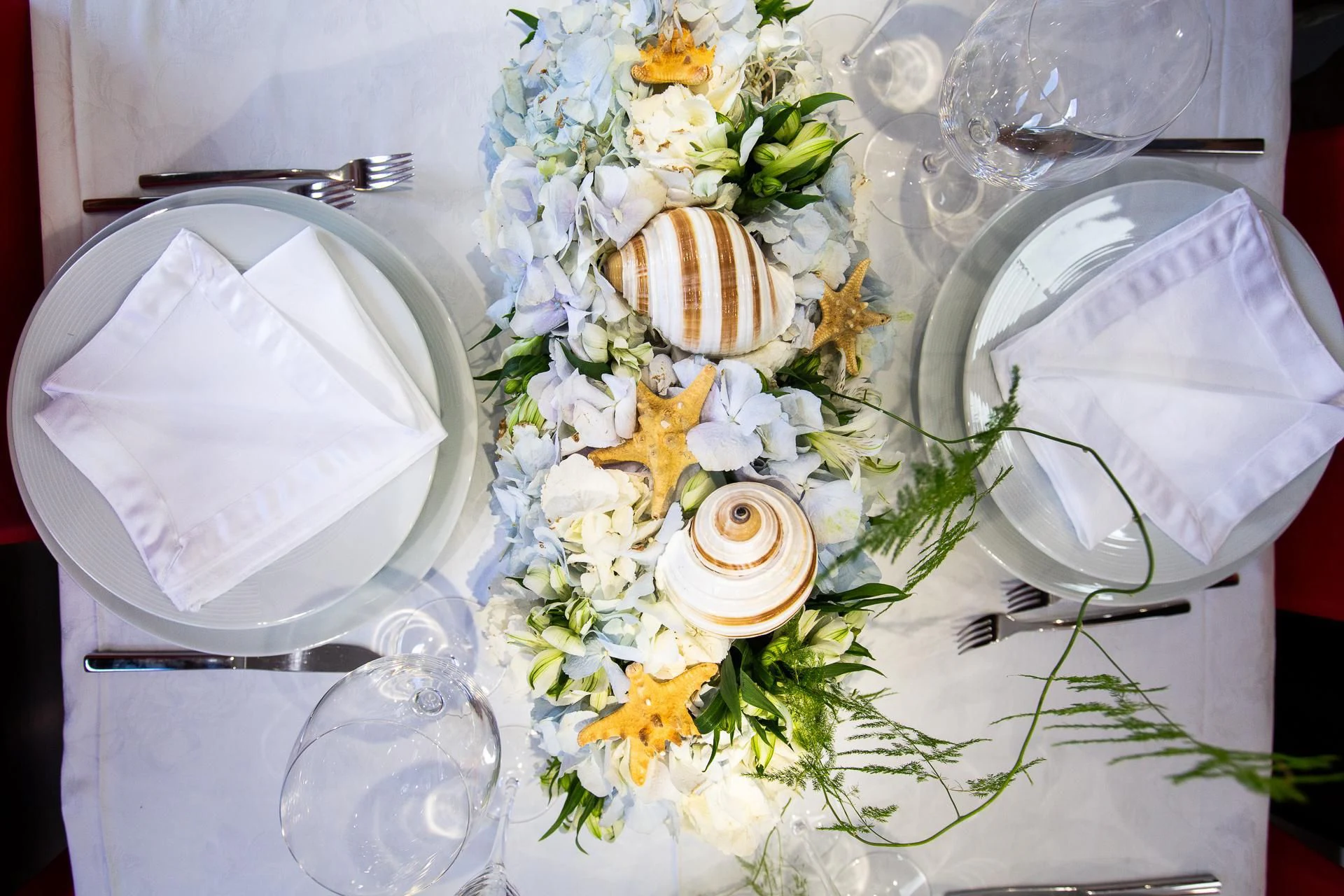 a table with flowers and plates aboard CAMILLA A Yacht for Sale