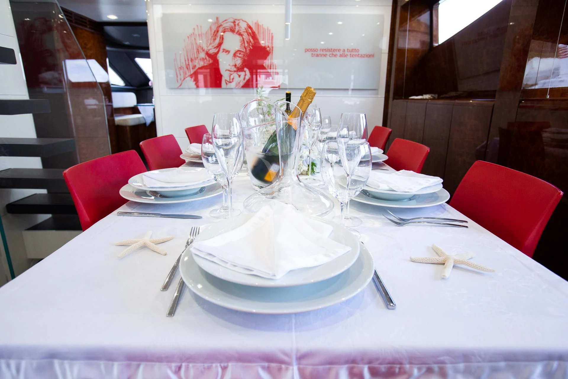 a table with plates and glasses aboard CAMILLA A Yacht for Sale