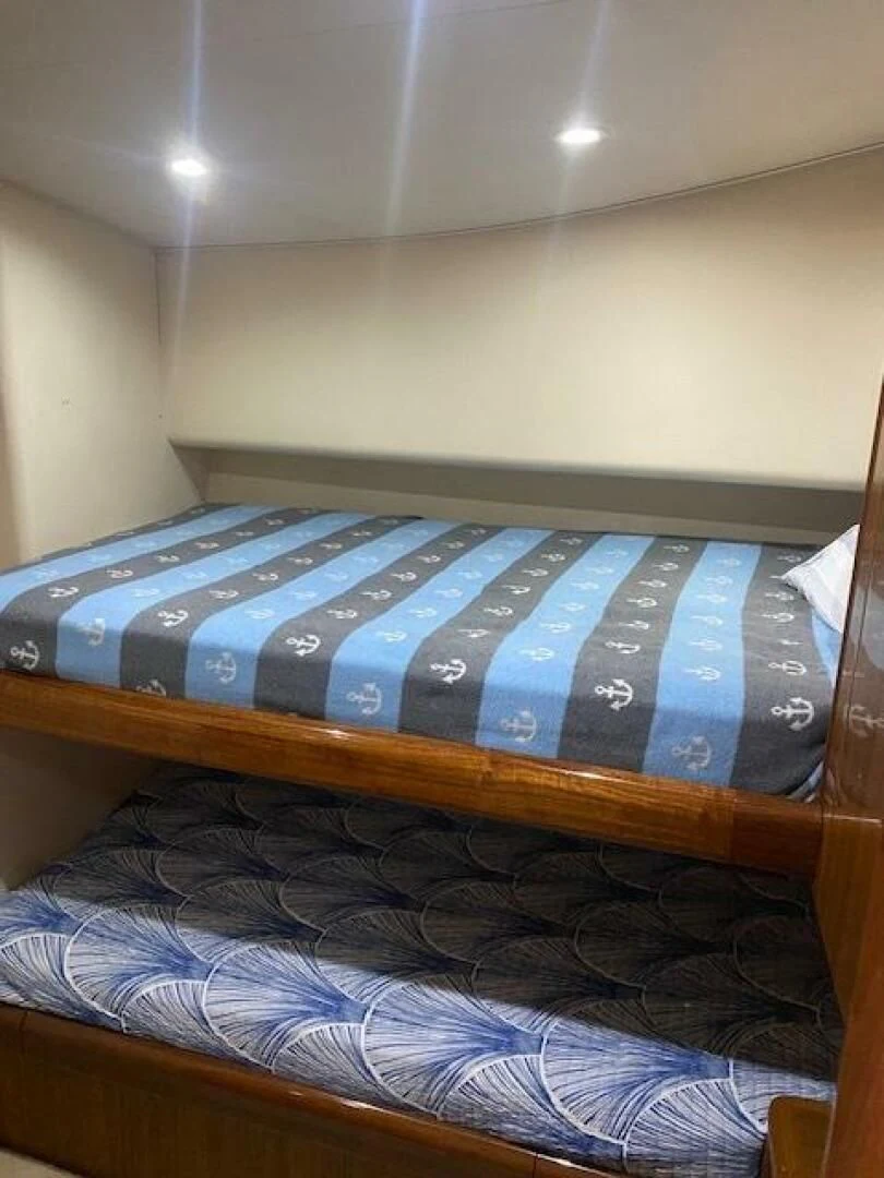 a bed with a blue and white blanket on it aboard STABILIZED Yacht for Sale