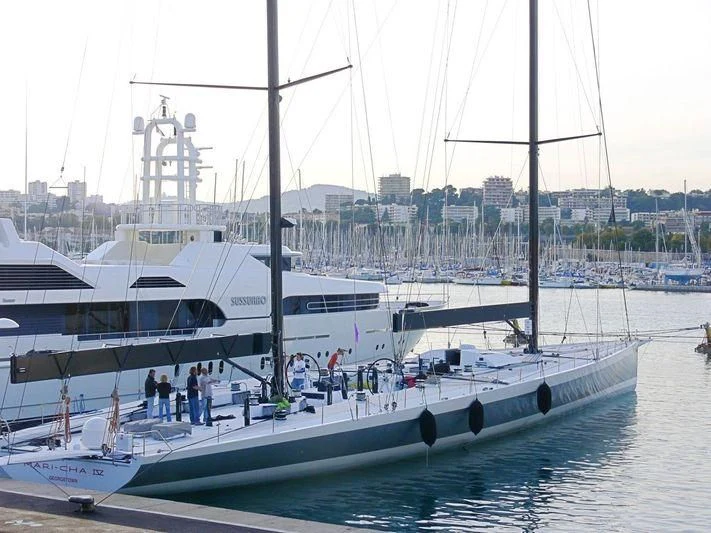 a group of people standing on a dock next to a large boat aboard SAMURAI Yacht for Sale